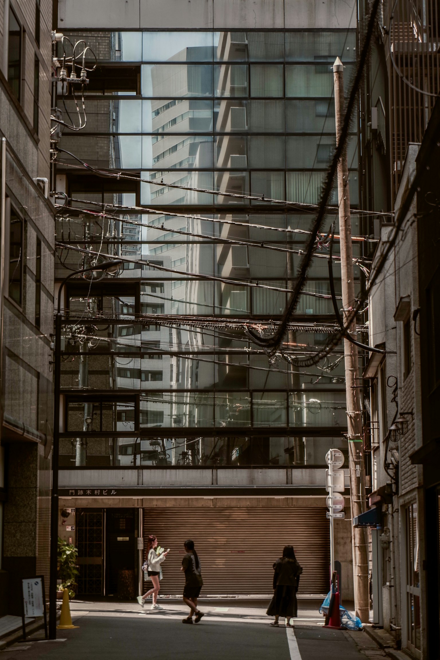 建筑之间的狭窄街道，有人走动和玻璃外立面