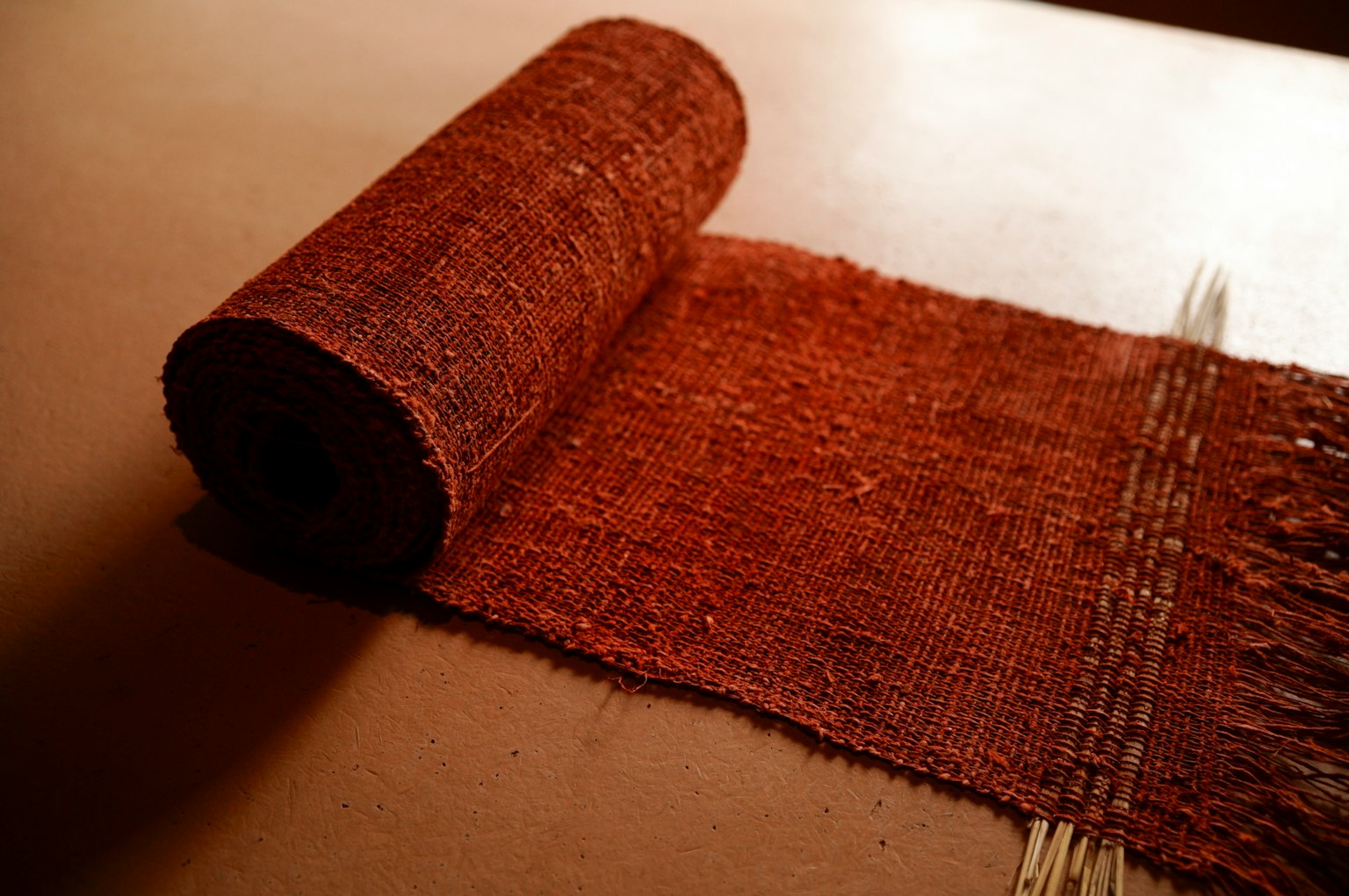 Image of a rolled reddish-brown fabric laid out