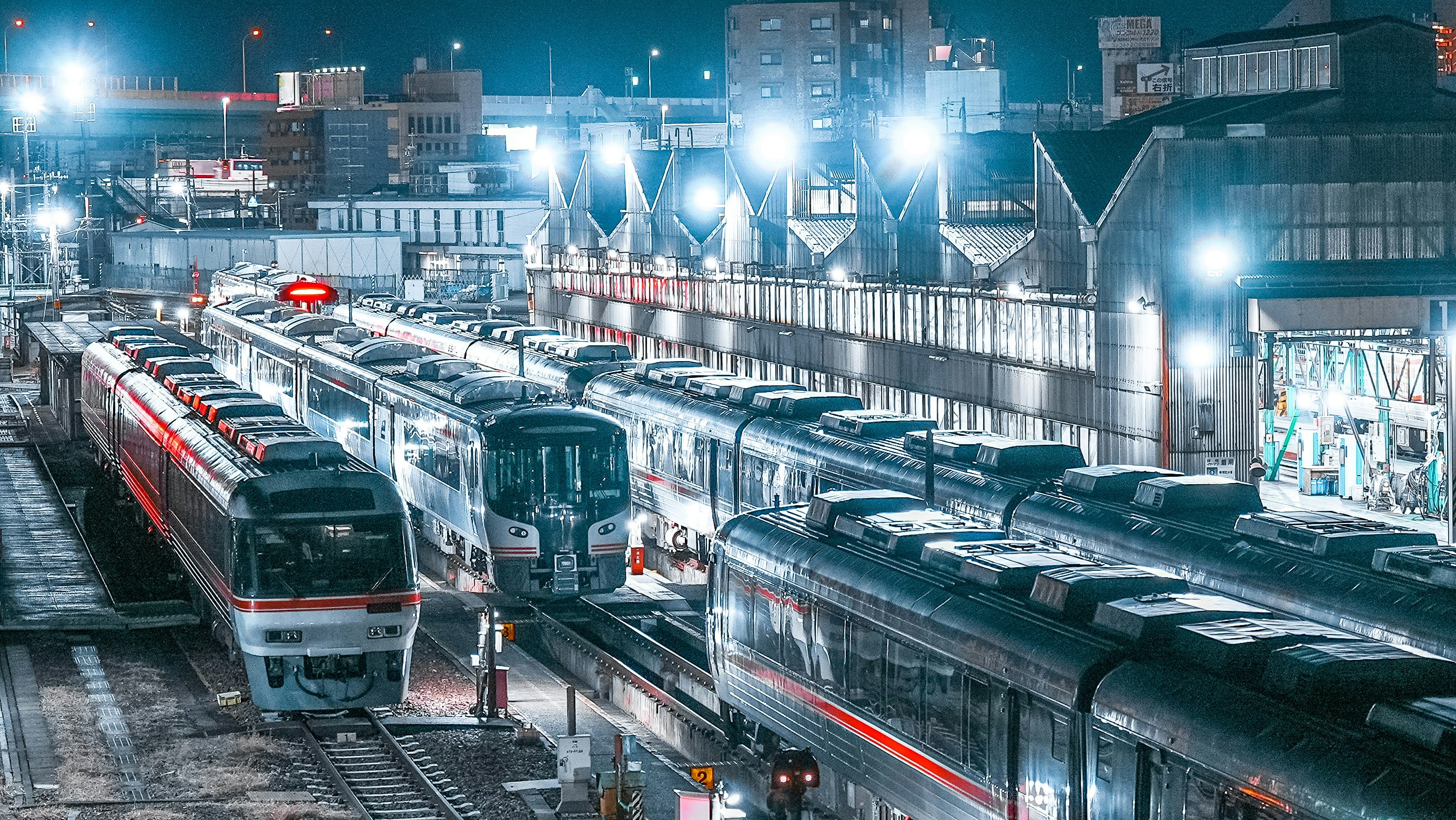 夜の駅で並ぶ電車の車両群