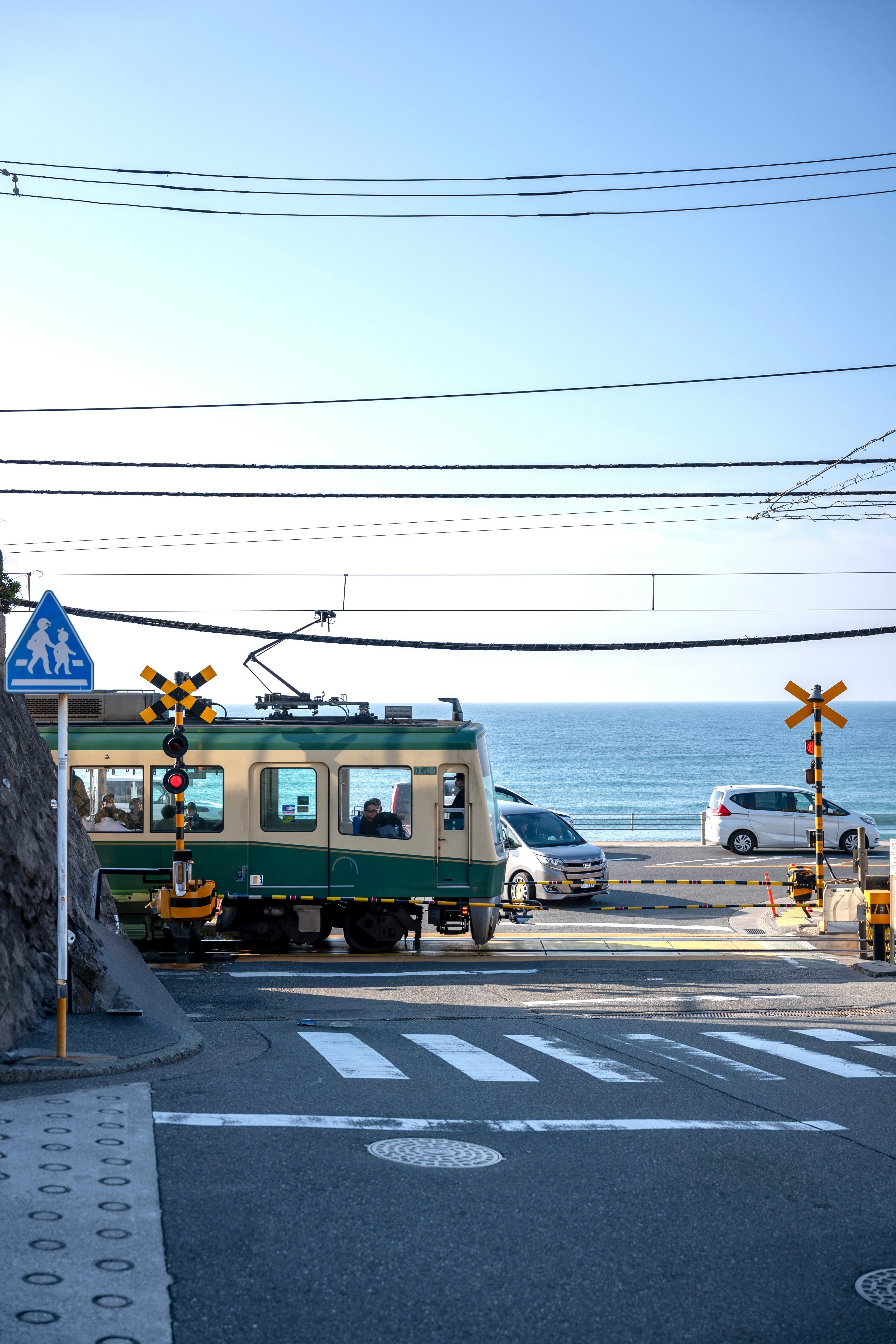 海边铁路道口的街角，信号灯与列车交汇