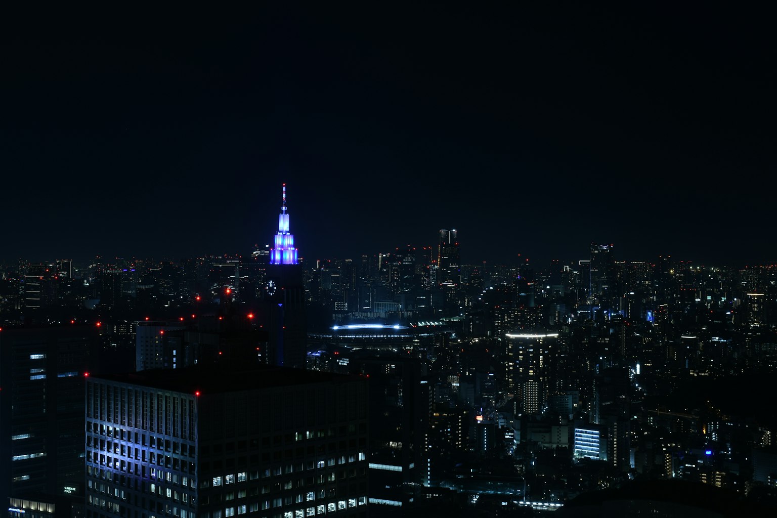Đường chân trời Tokyo vào ban đêm với Tòa nhà Empire State được chiếu sáng bằng màu xanh