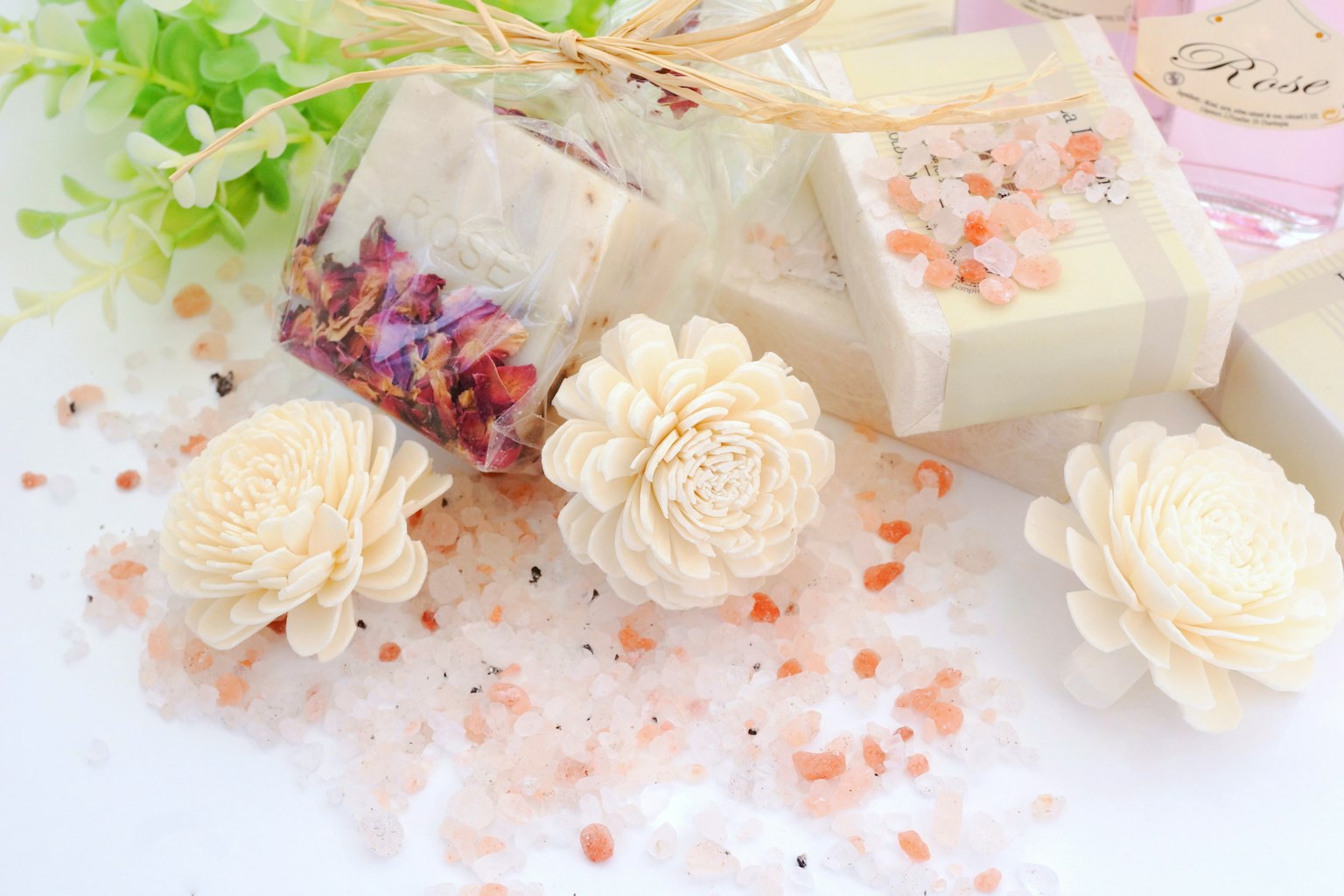 Saponi fatti a mano con erbe e petali di fiori affiancati a fiori decorativi in un bellissimo arrangiamento