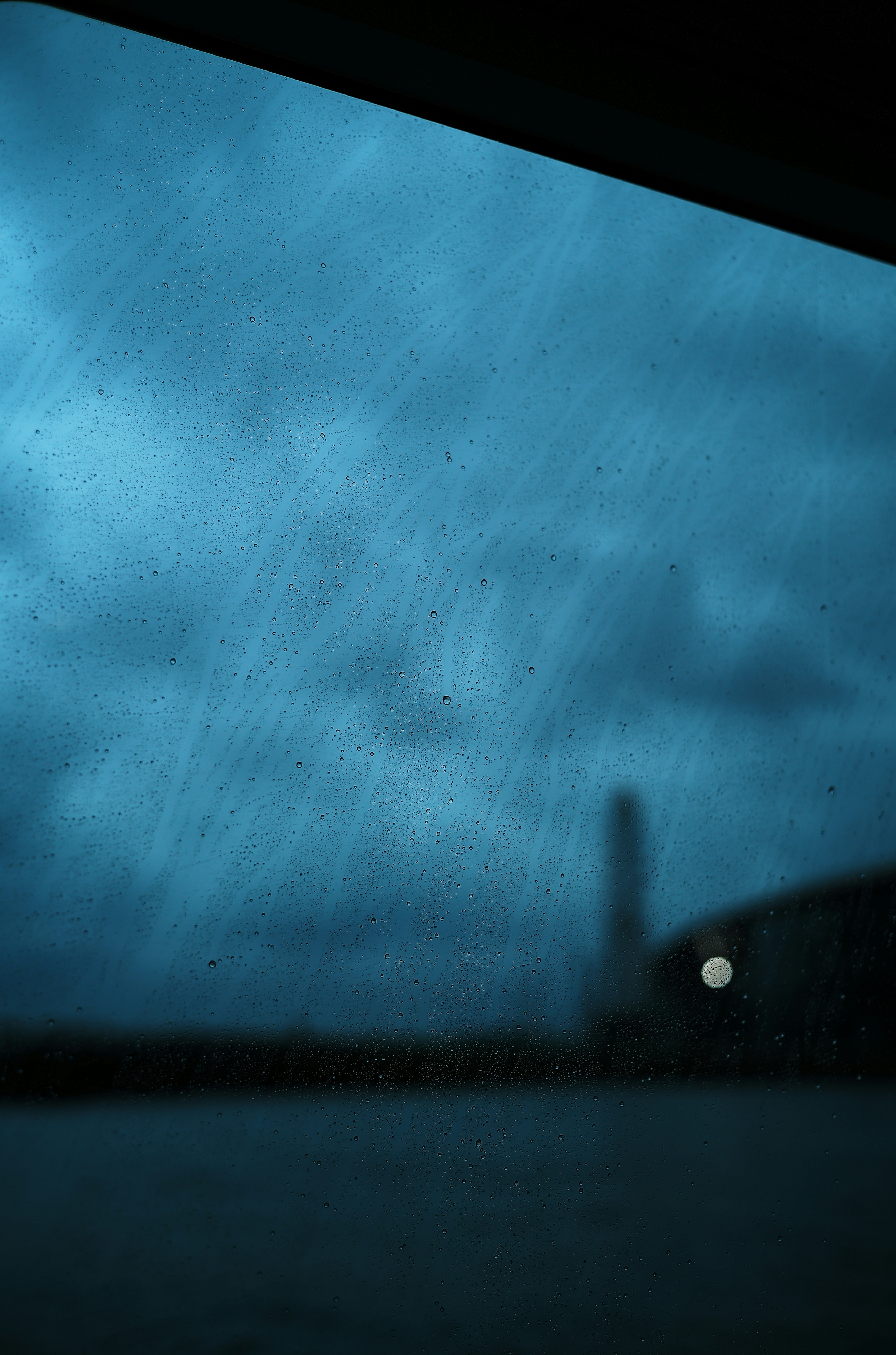 青い空気感のある暗い夜の水面と光のにじみ