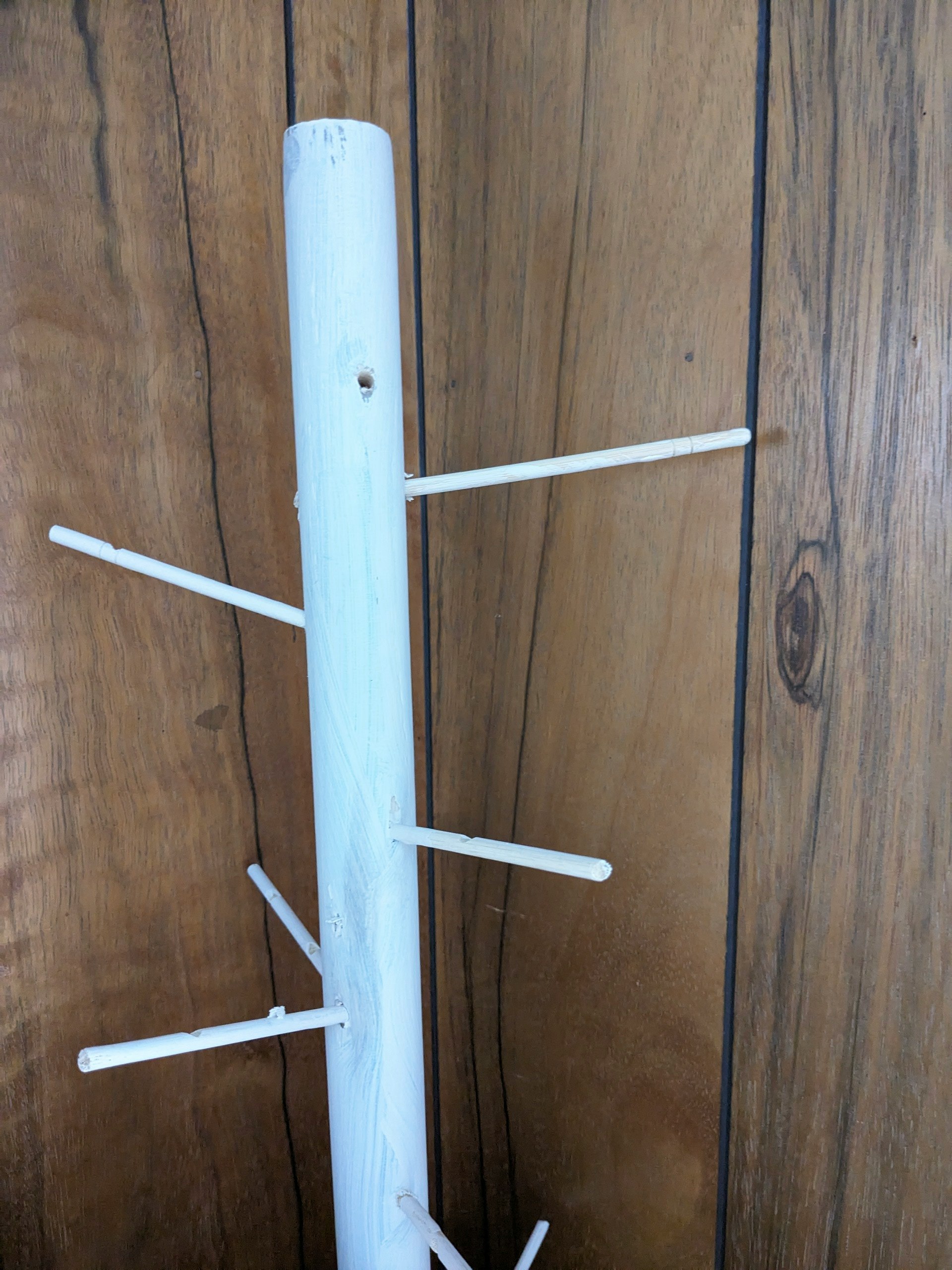 安装在木墙上的白色晾衣架立柱
