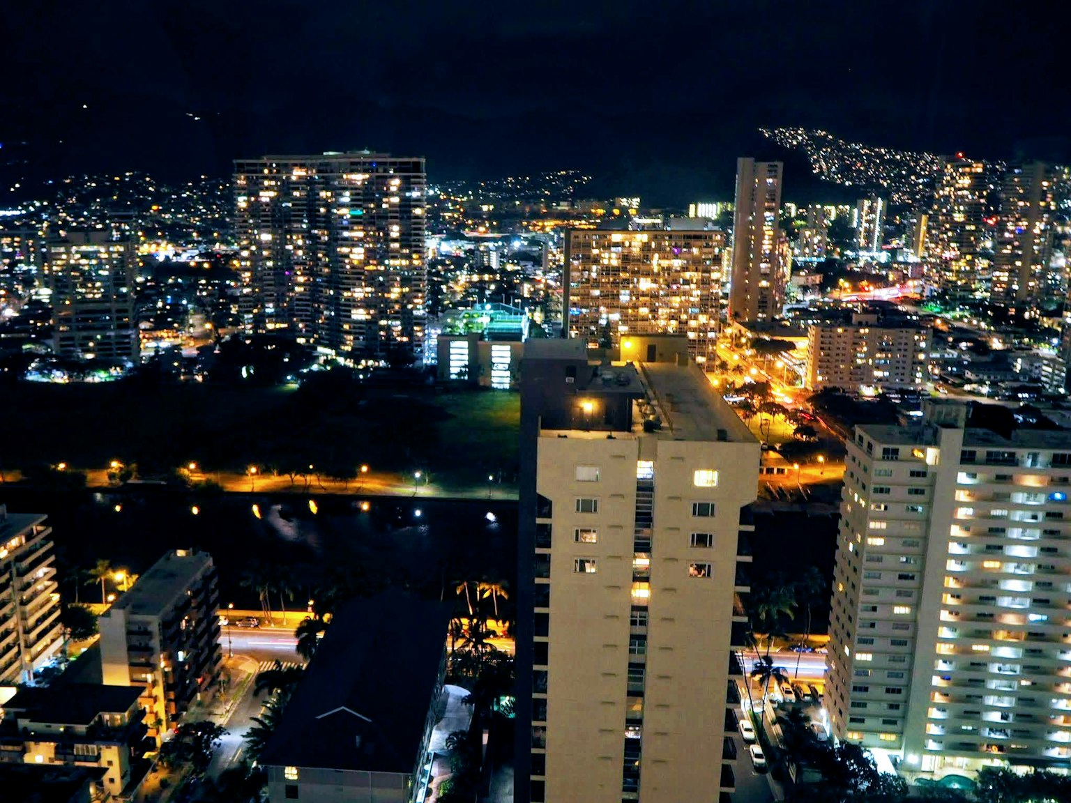 Paysage urbain nocturne avec des gratte-ciels illuminés et des lumières vives