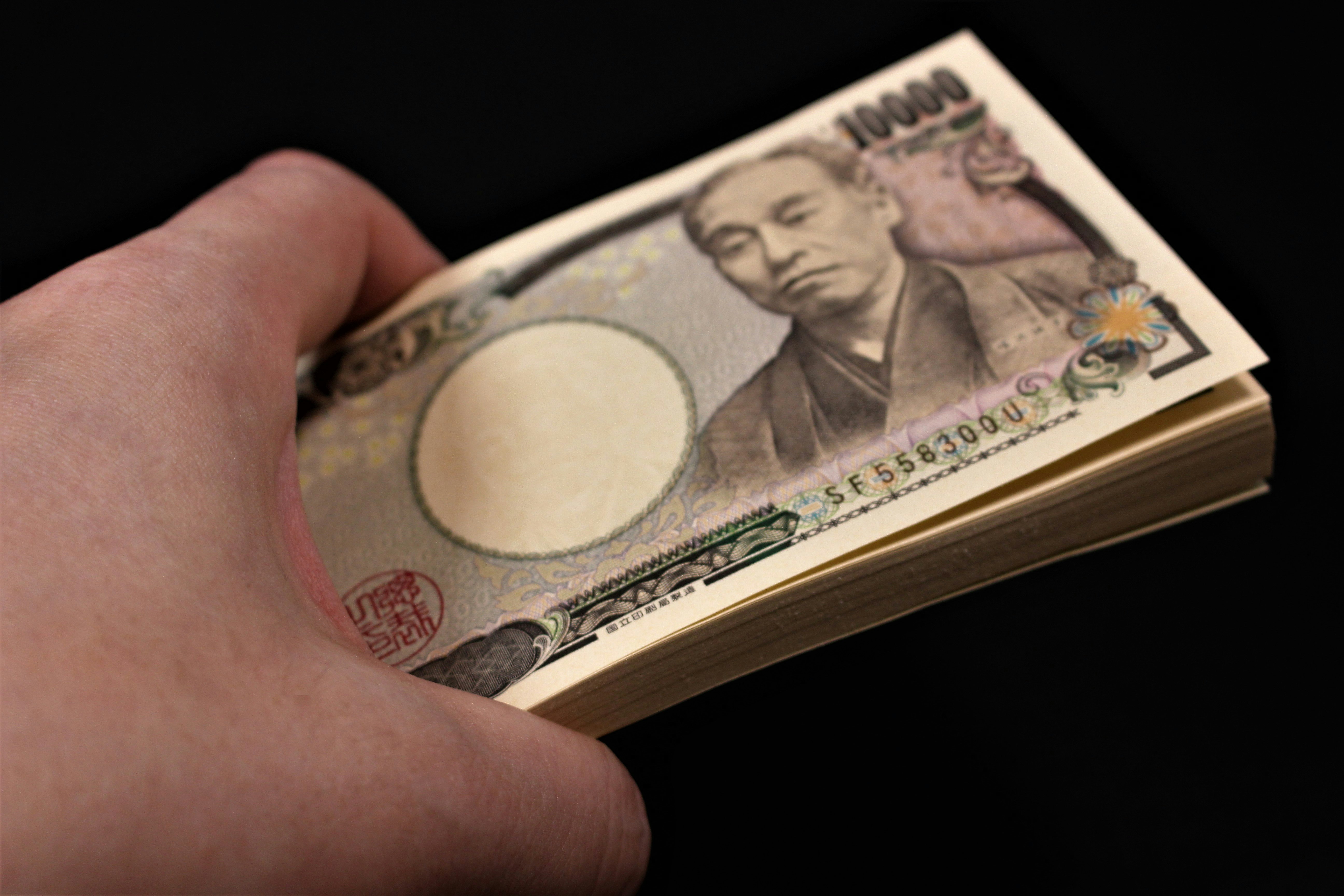 手拿一疊紙幣
