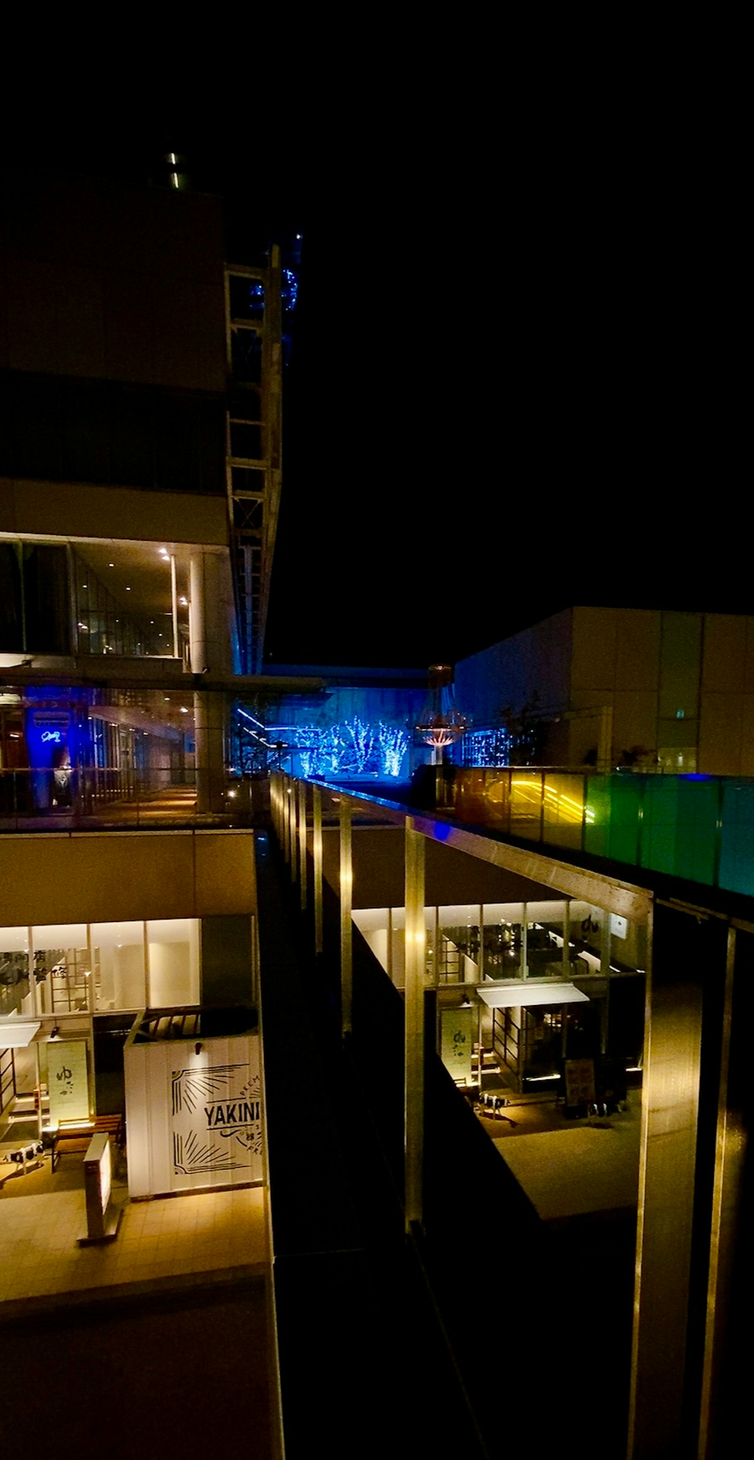 Esterno di un edificio moderno con illuminazione colorata in un contesto urbano notturno
