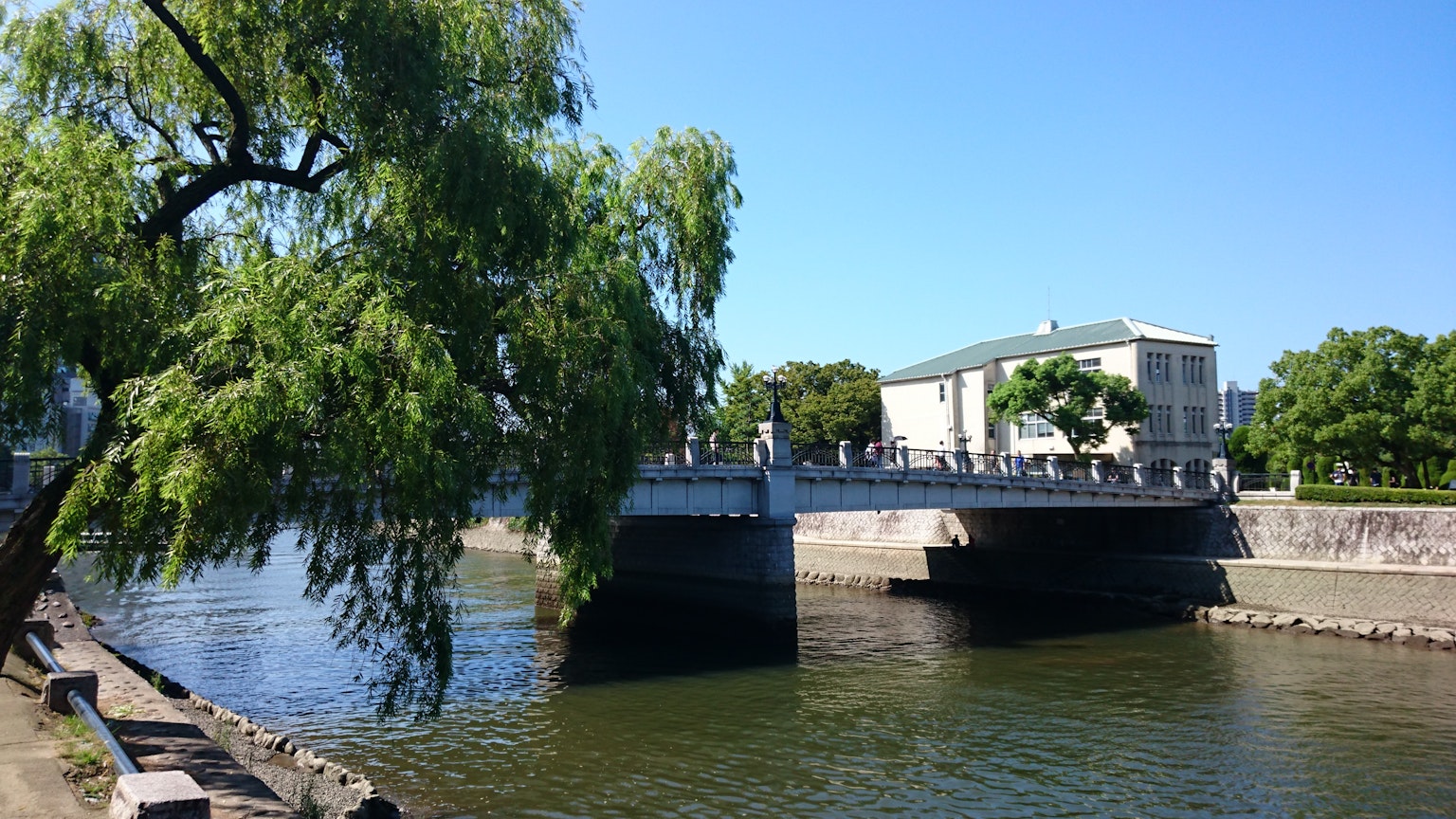 Brücke über einen ruhigen Fluss, umgeben von grünen Bäumen