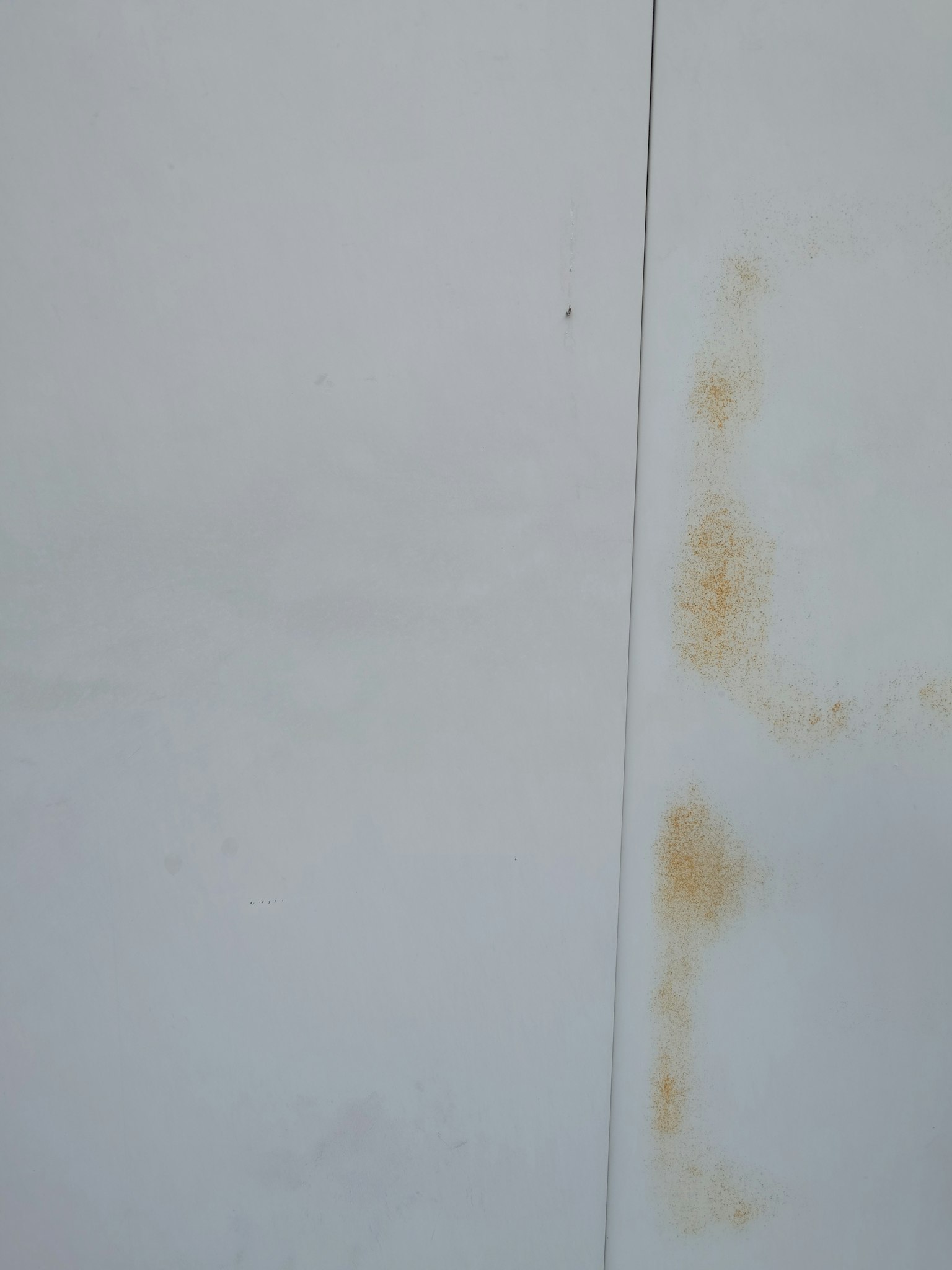 Weißer Wand mit sichtbaren braunen Flecken