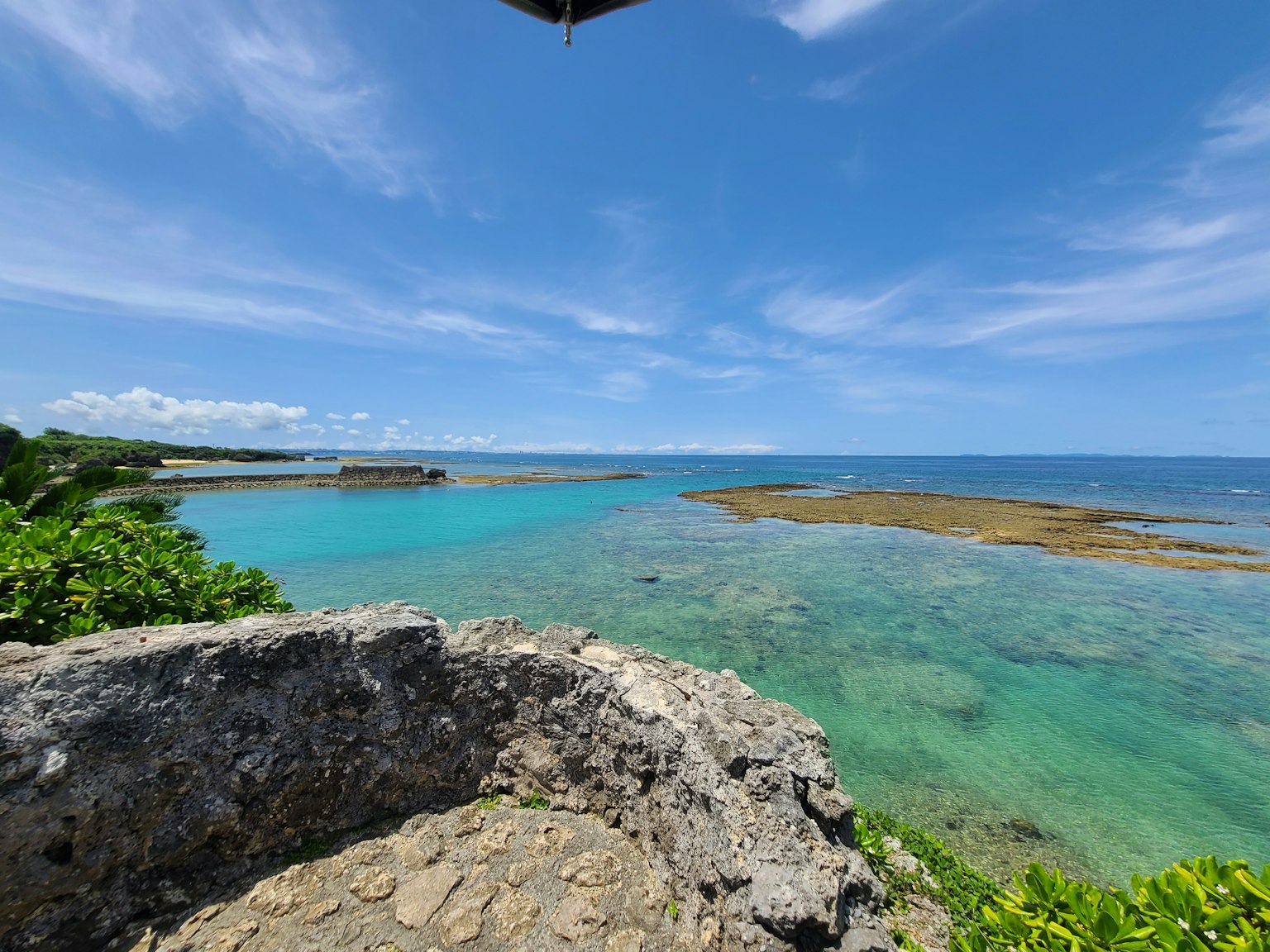 Hermosa vista del océano azul y el cielo con una costa rocosa y vegetación