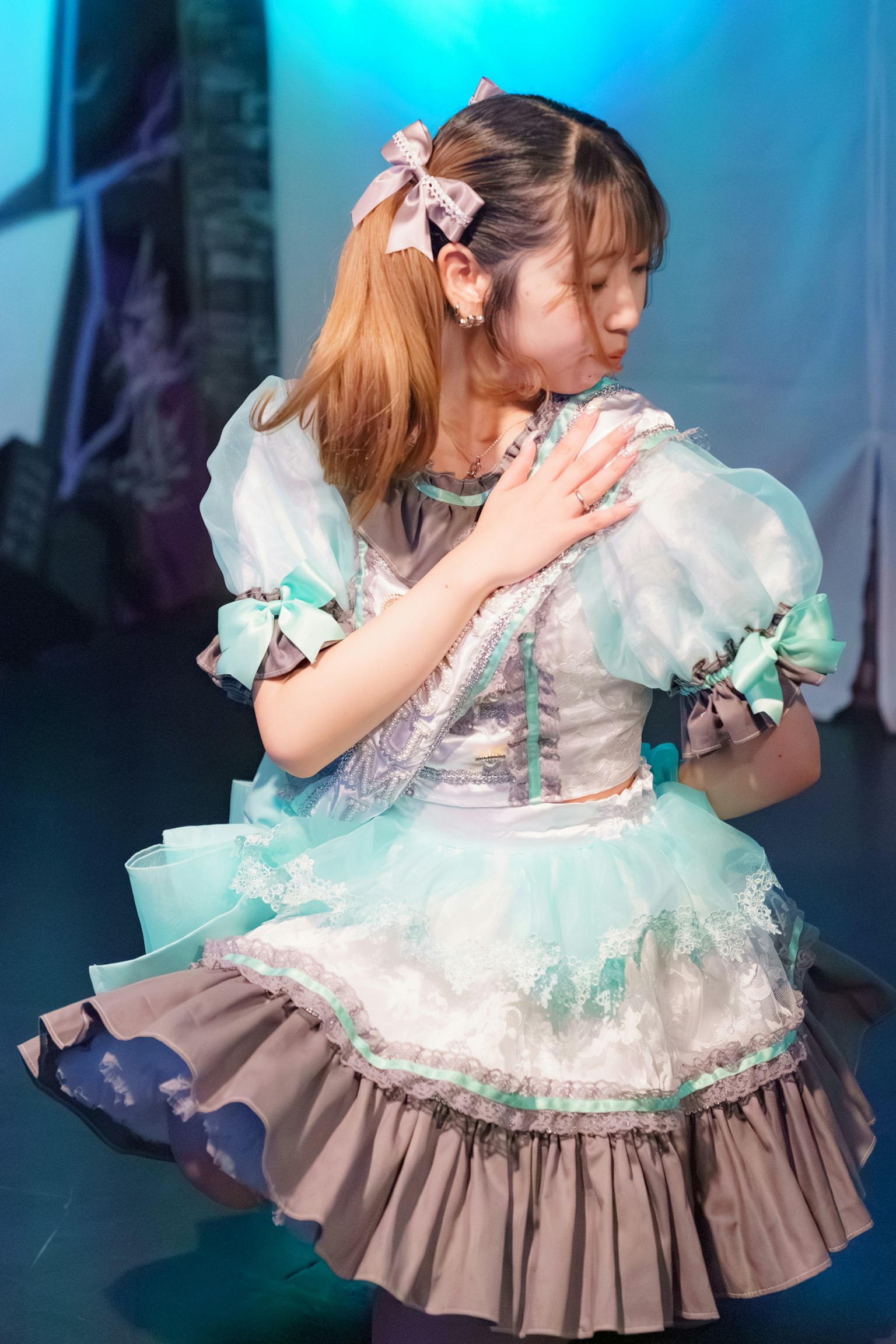 青とグレーのドレスを着た少女が踊っている姿