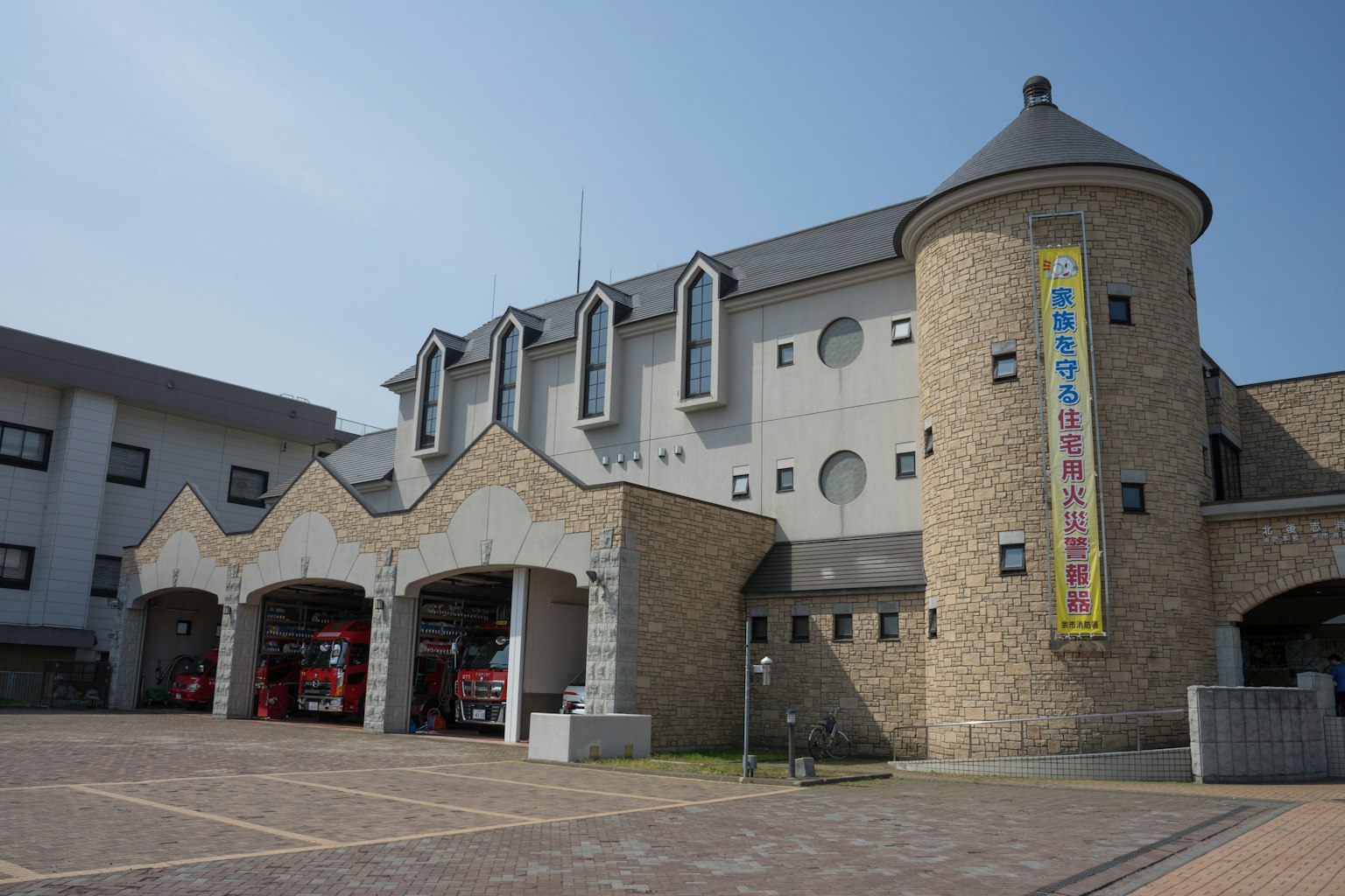 Außenansicht einer Feuerwehr mit Steinturm und modernem Design