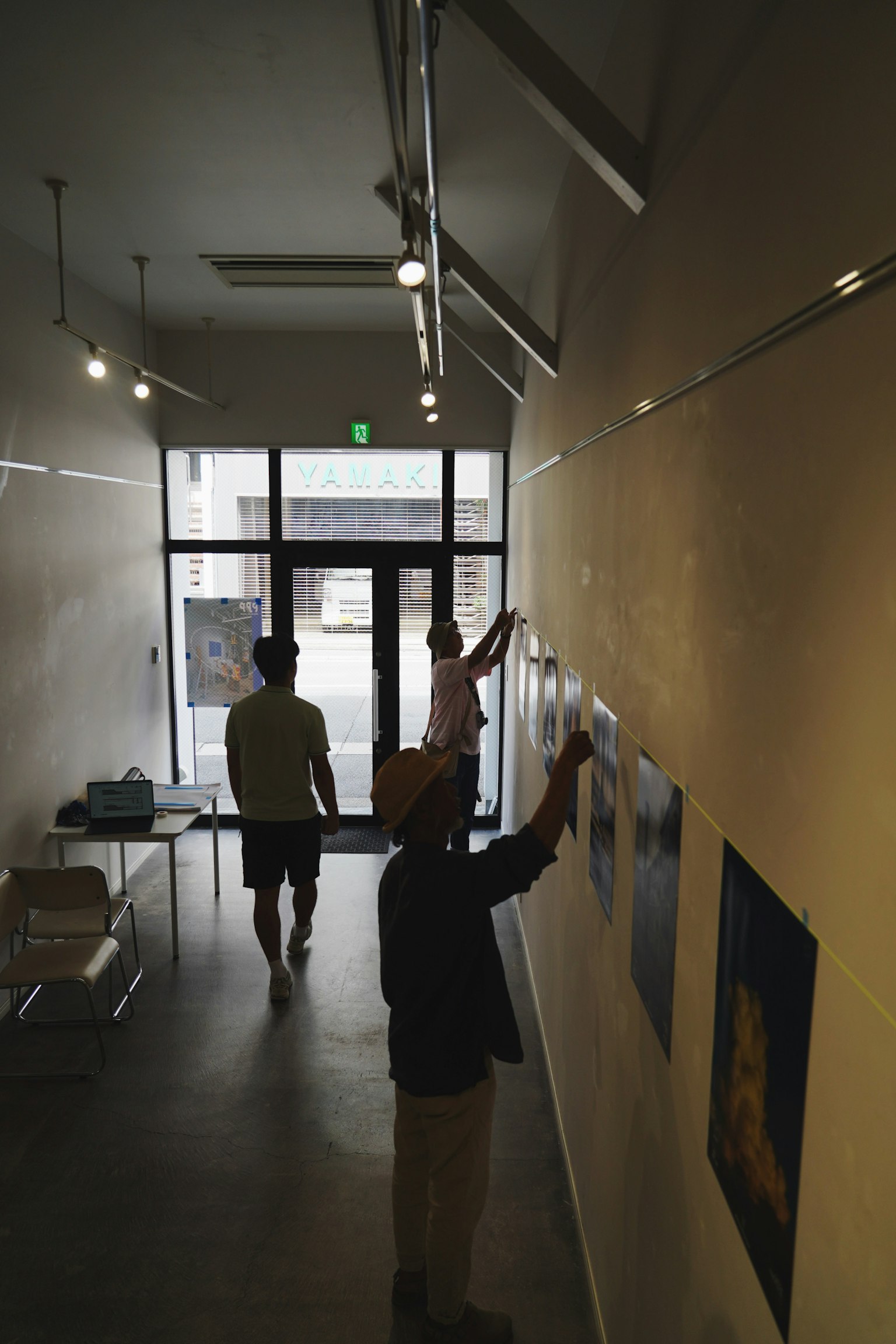 ギャラリーで作品を展示している人々の姿が見える