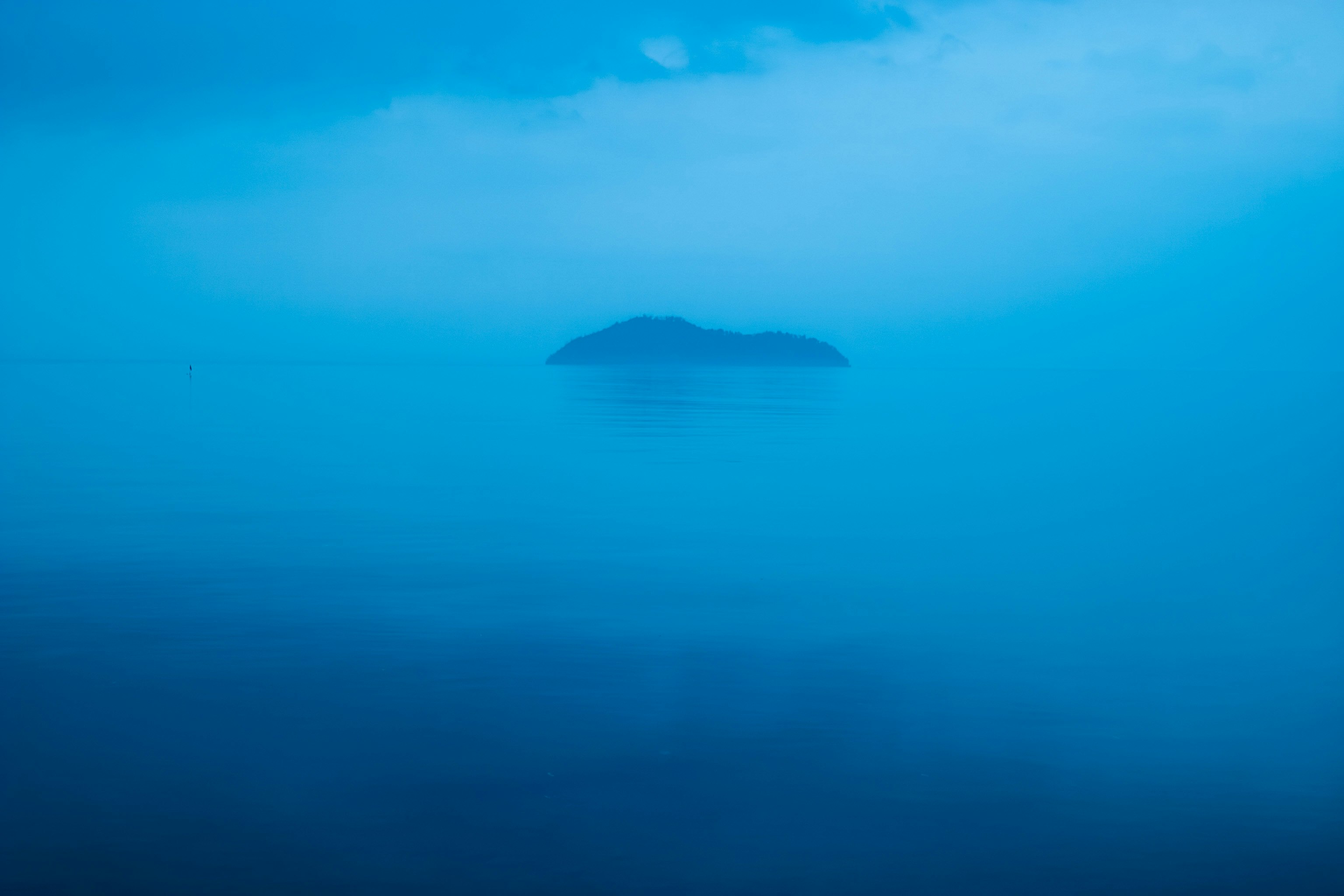 青い海に浮かぶ小島のシルエット
