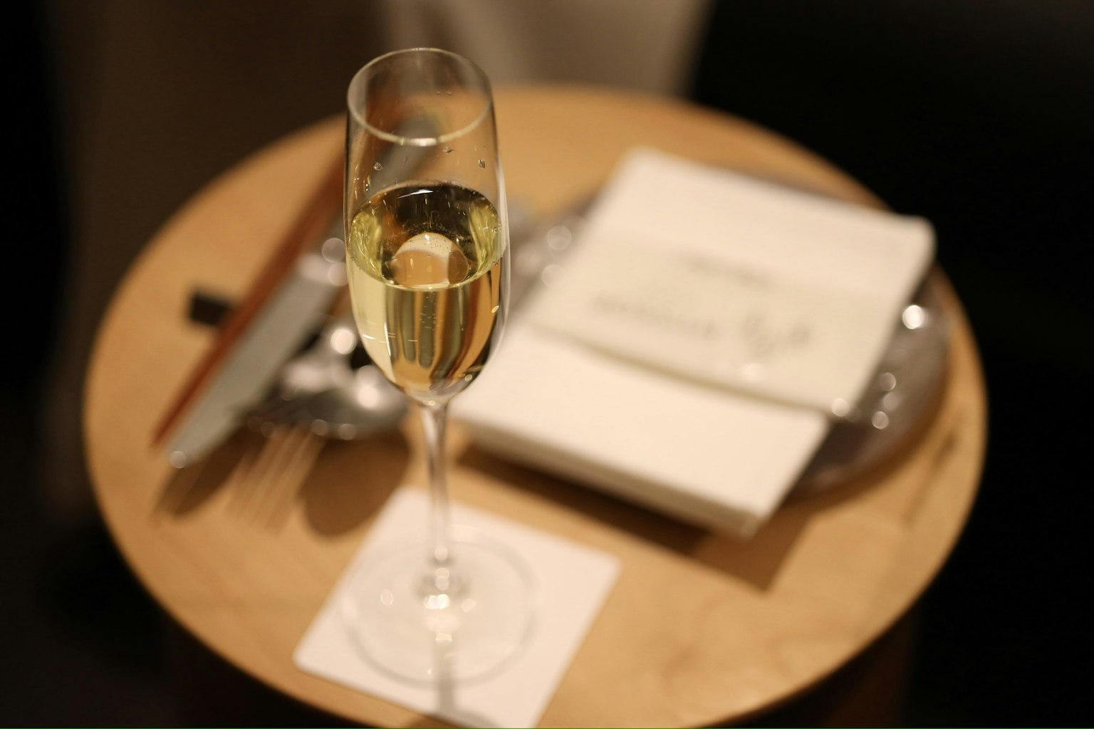 Verre de champagne sur une table en bois avec une serviette et des couverts