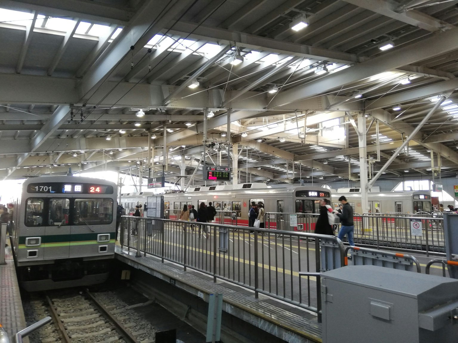 View of a train station platform with people and trains