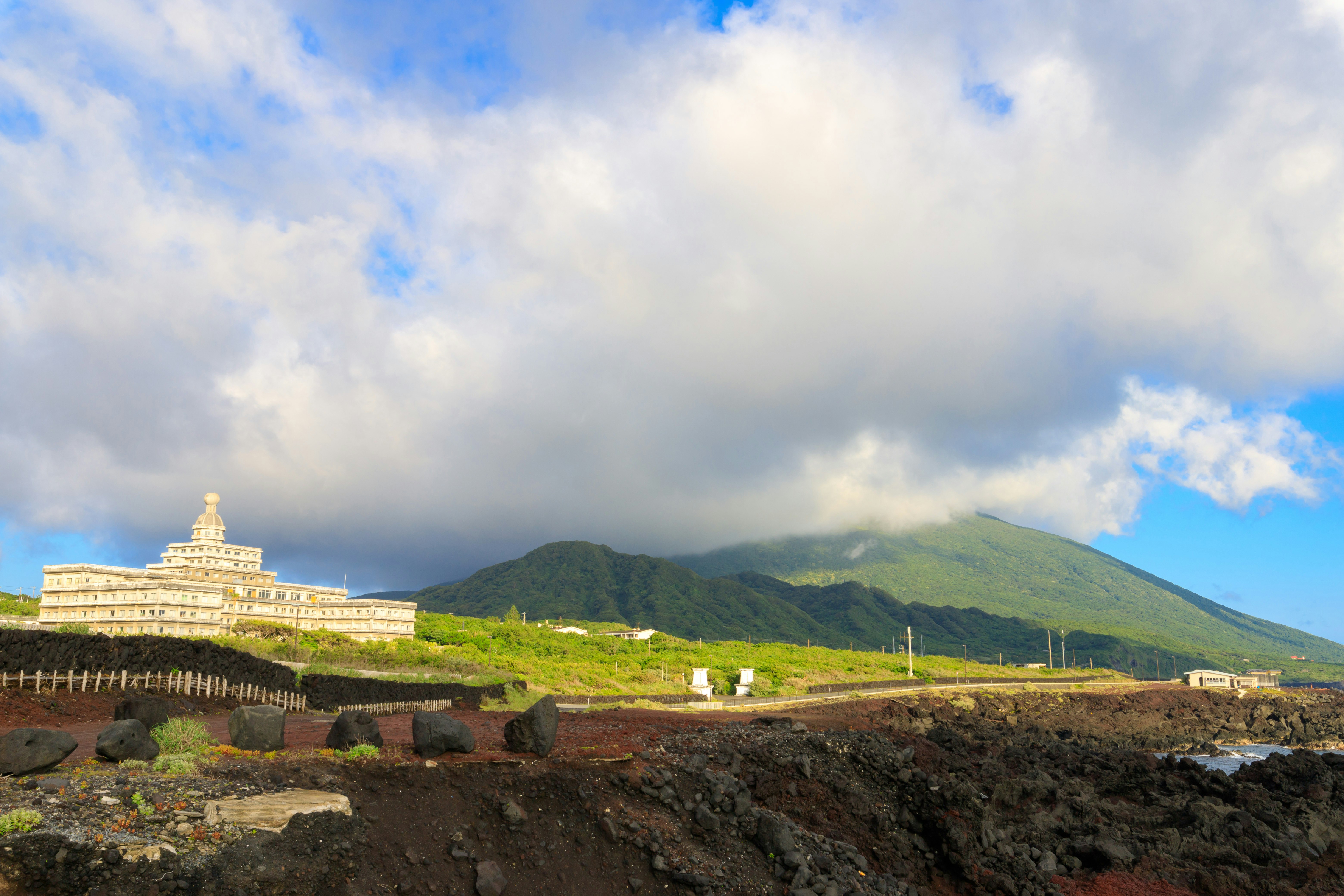 海辺の丘に建つ白い寺院と緑の山並み