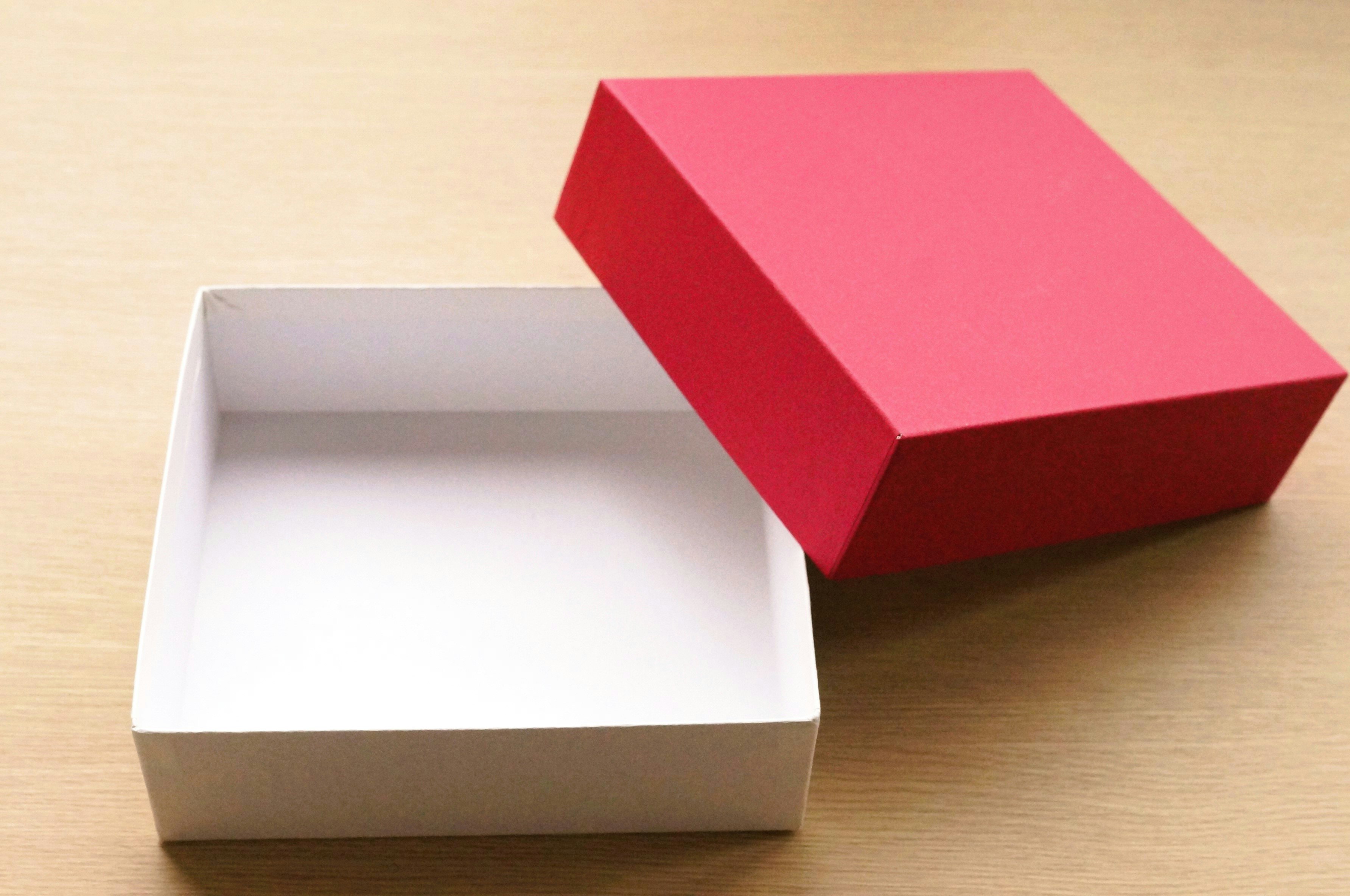 kotak hadiah dengan tutup merah dan kotak putih yang terbuka