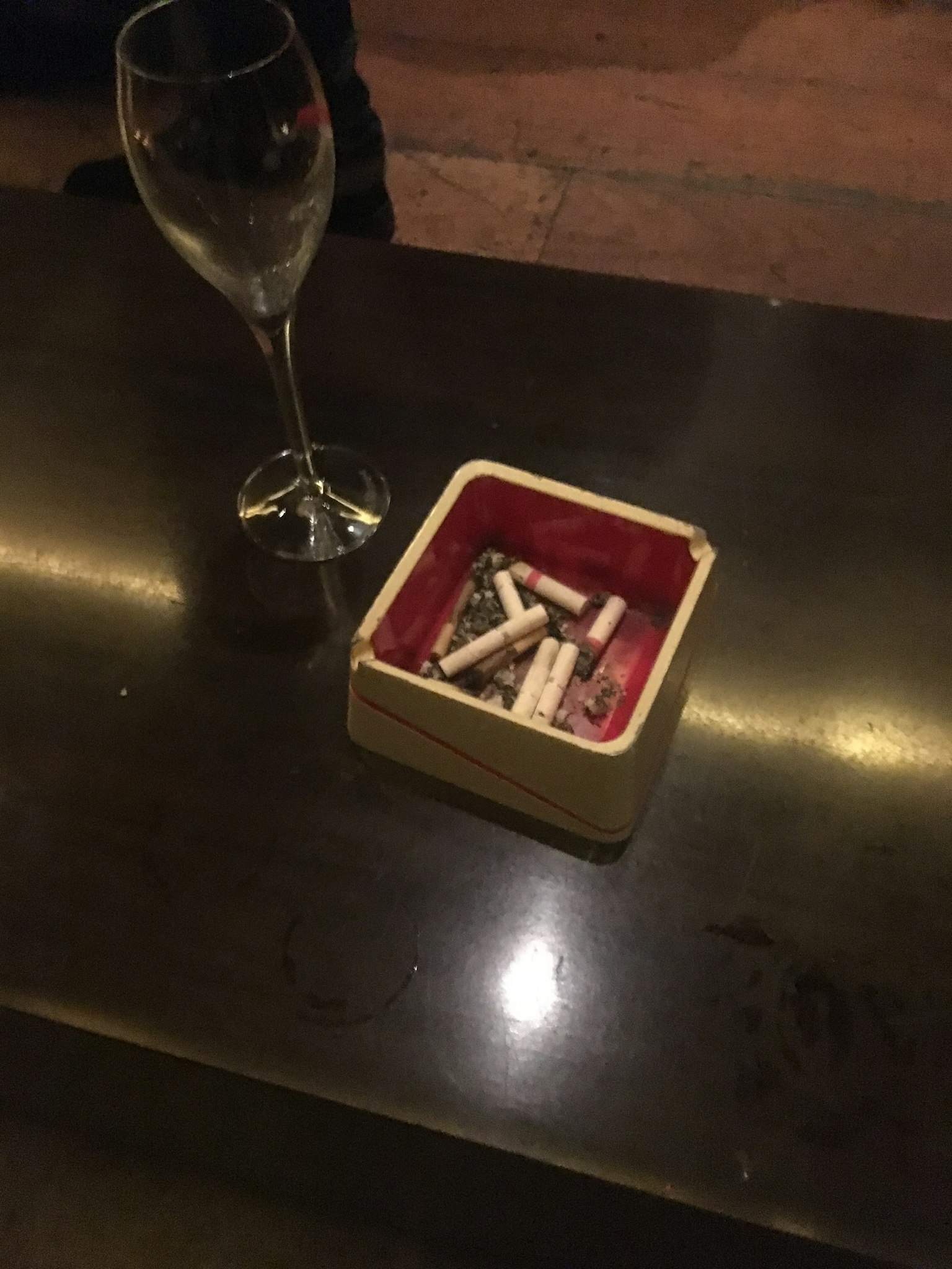 Un verre de vin à côté d'une boîte de cigarettes sur une table