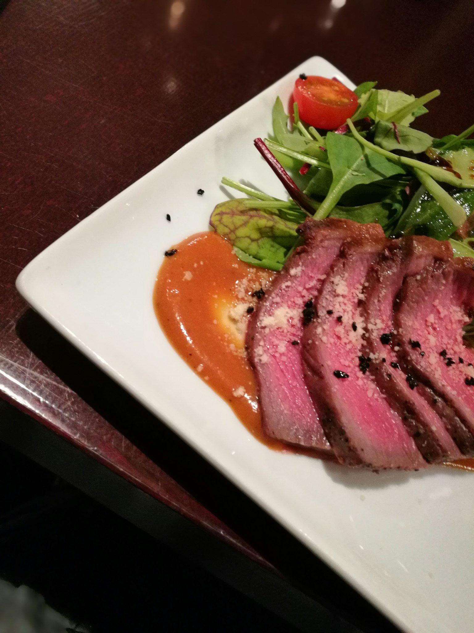 Une assiette avec de la viande tranchée et une salade fraîche