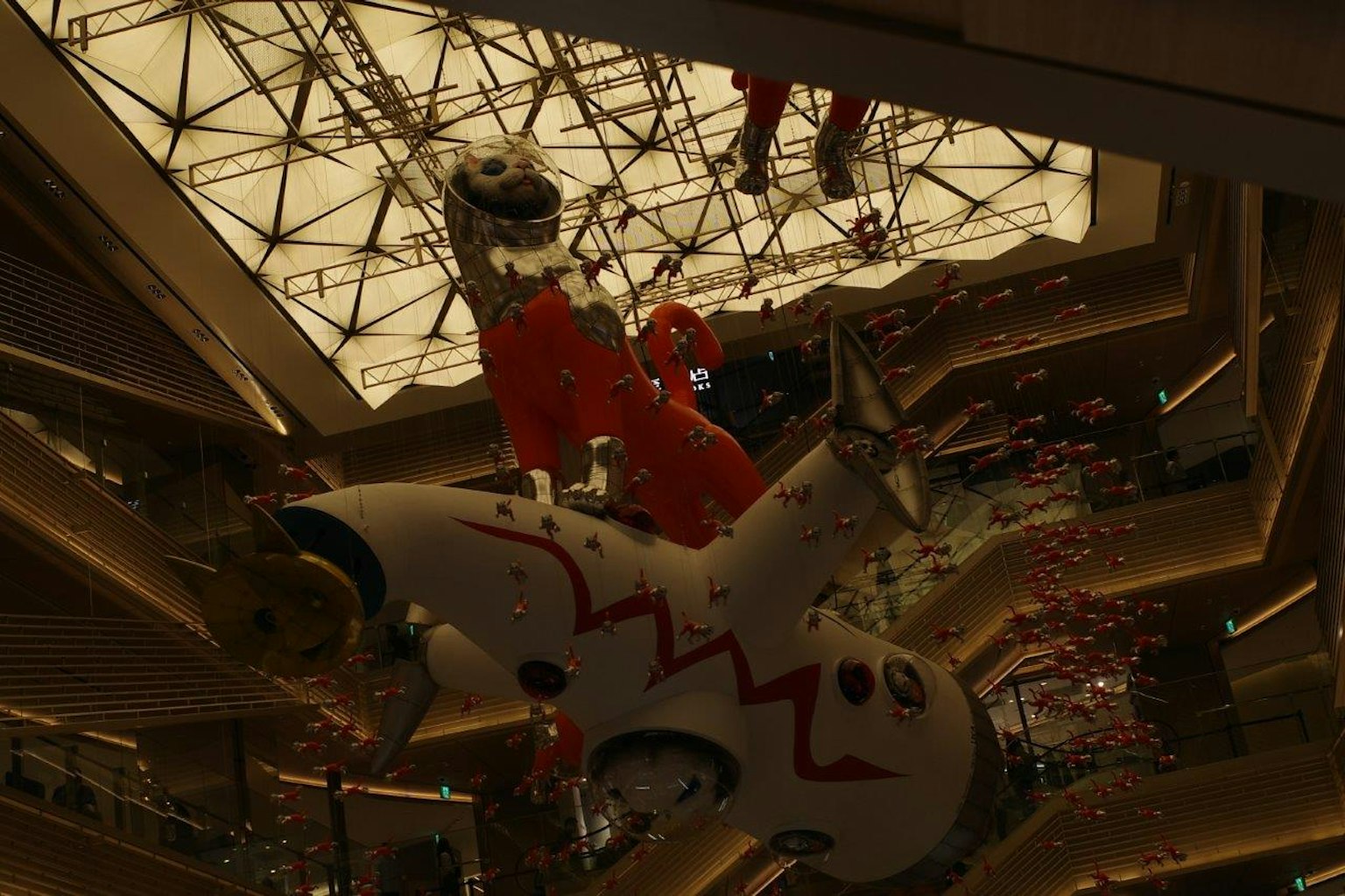 Nave espacial suspendida con un personaje vestido de rojo del techo
