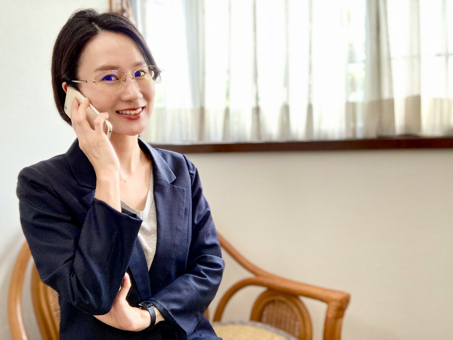 Một người phụ nữ trong bộ đồ công sở đang nói chuyện qua điện thoại