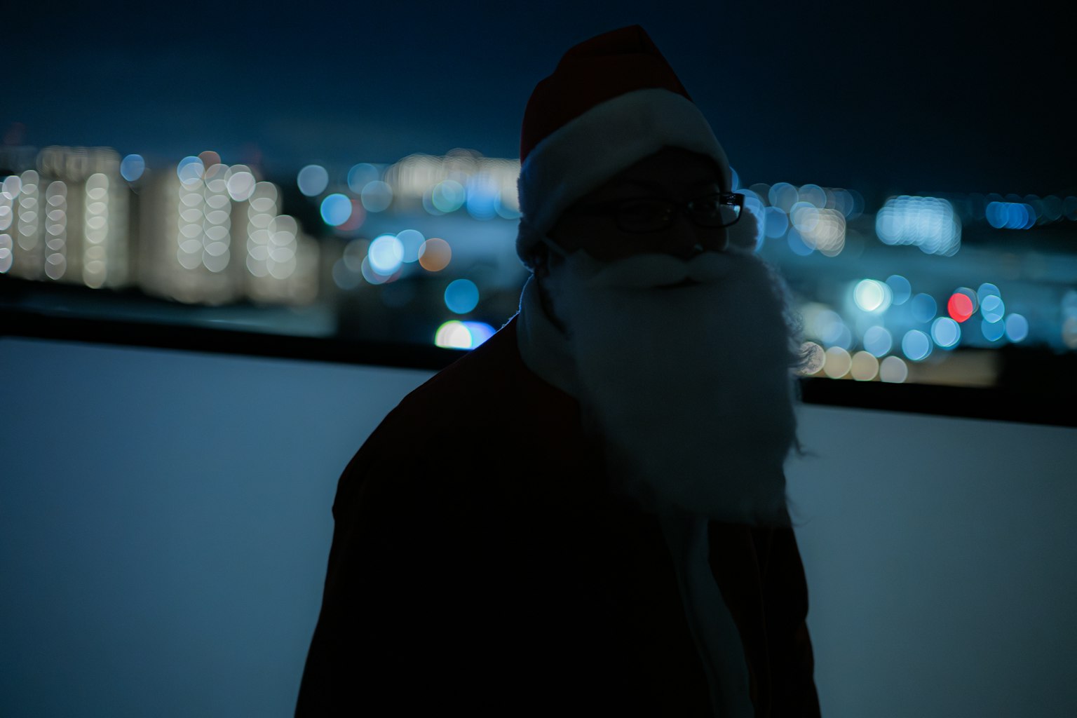 Silhouette von Santa Claus vor einer nächtlichen Stadtlandschaft