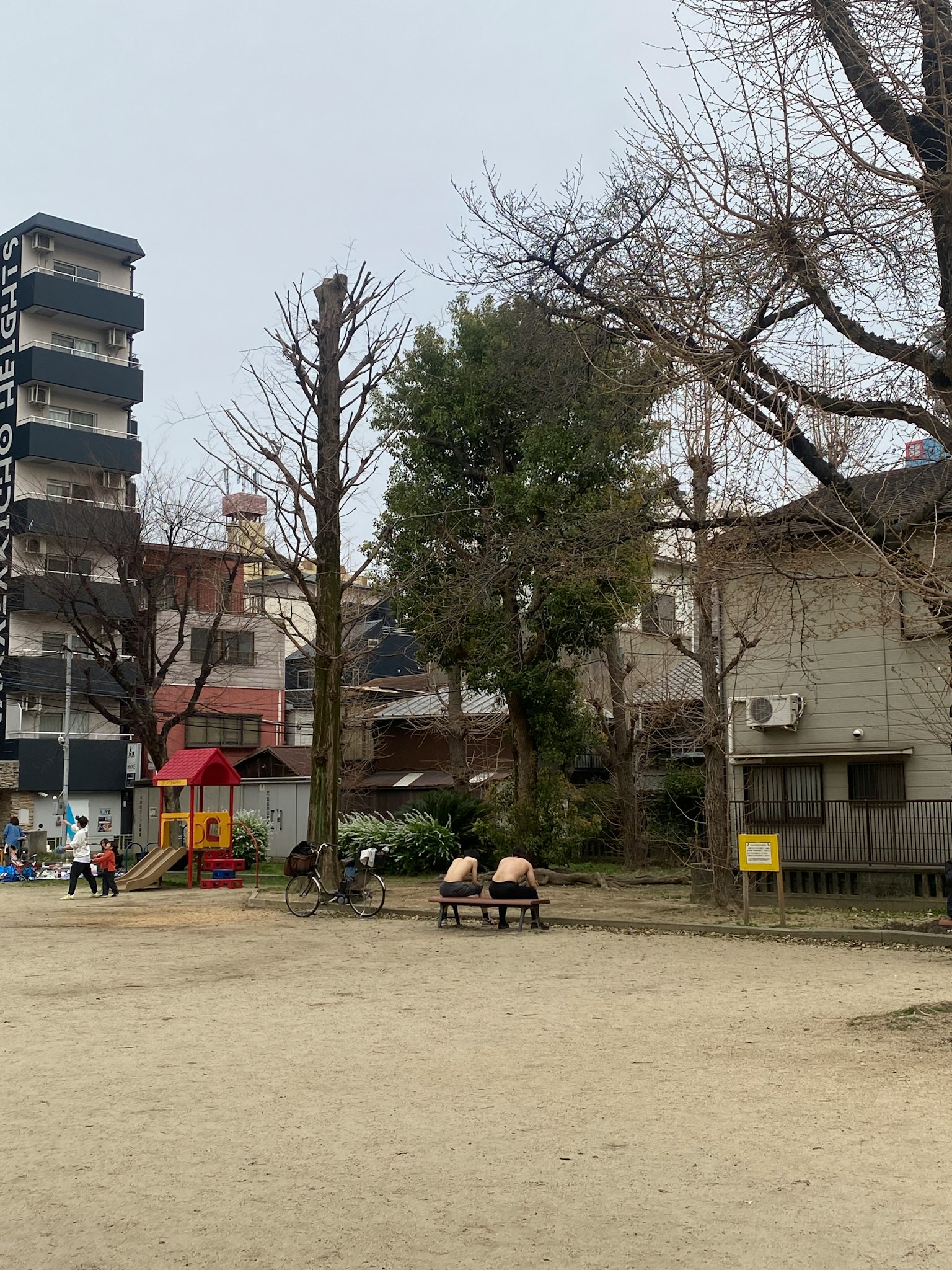 Bambini che giocano in un parco con edifici circostanti