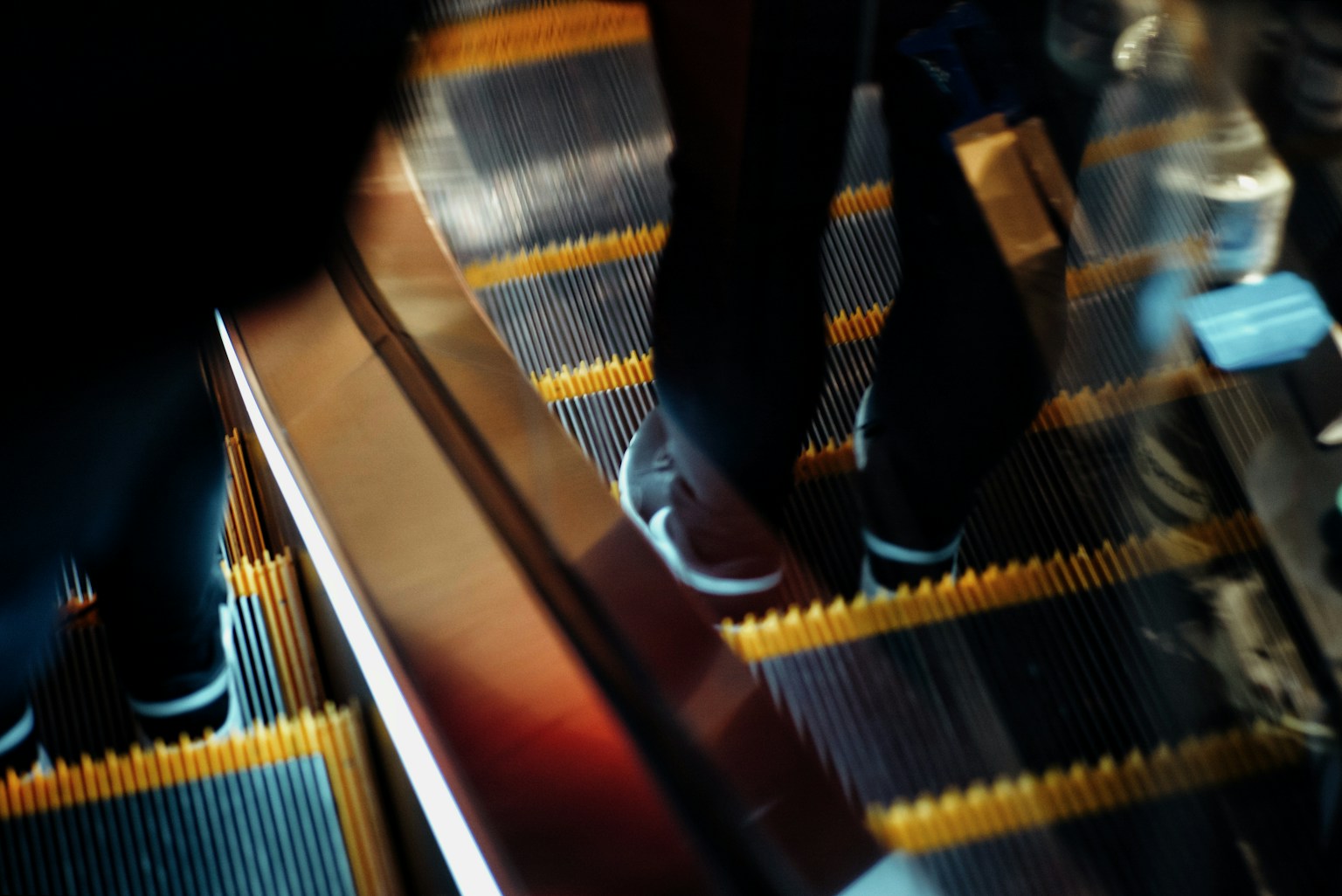 Close-up of feet on an escalator with motion blur