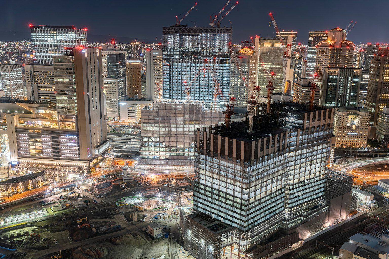 Paysage urbain nocturne avec des gratte-ciels et des sites de construction éclairés
