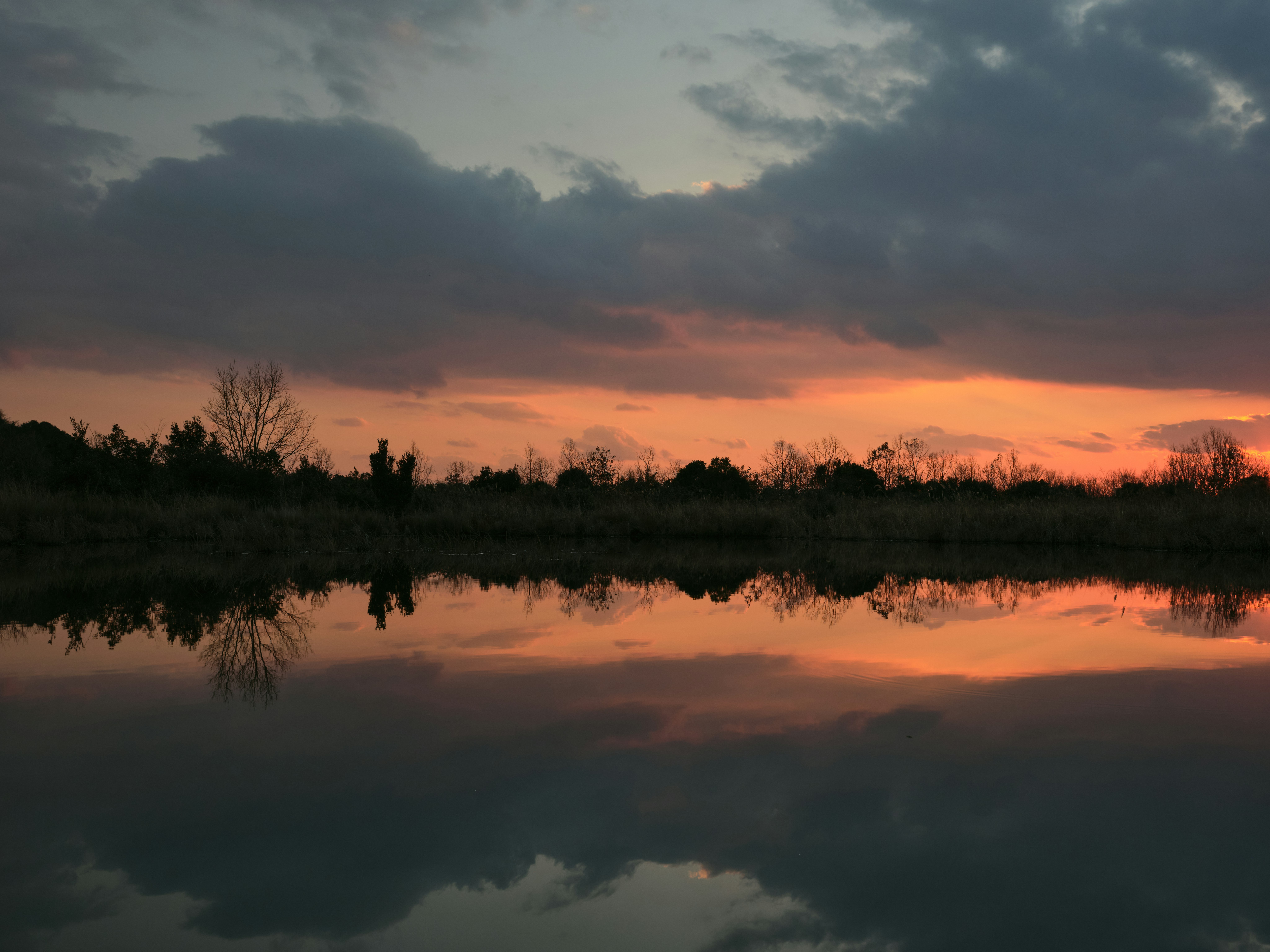 Refleksi pemandangan awan senja di atas air tenang