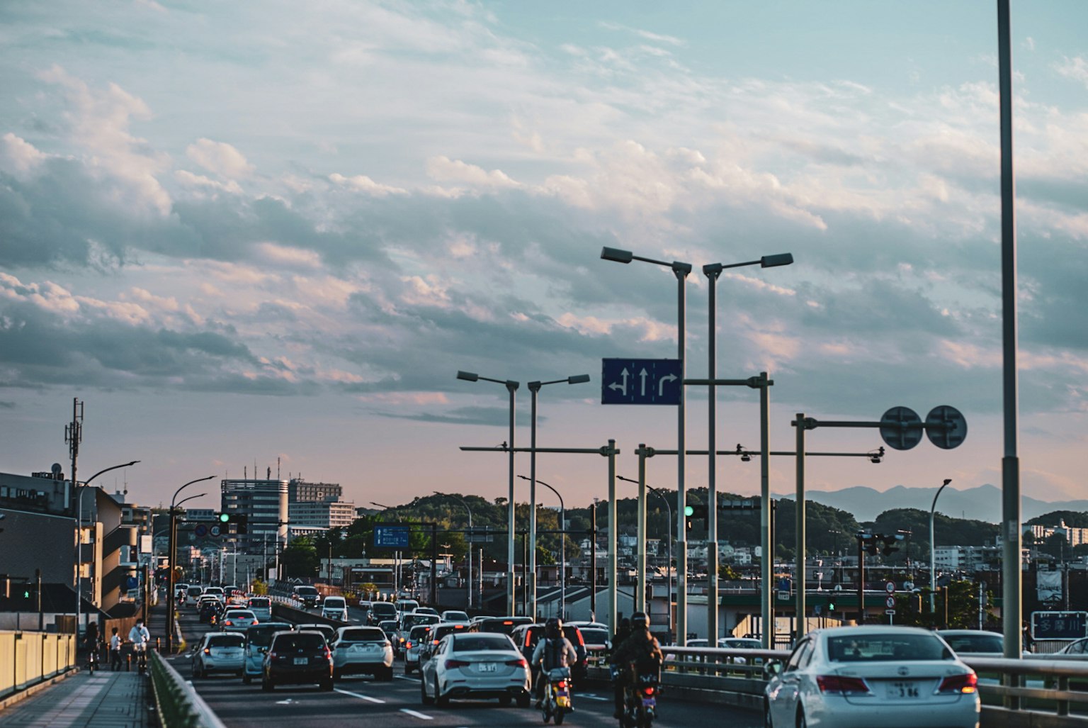 Scène de circulation urbaine au crépuscule avec de nombreux véhicules sur la route et des nuages bleus dans le ciel