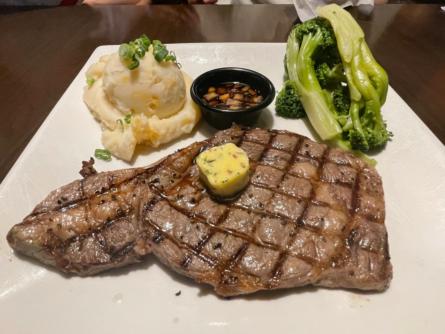 Gegrilltes Rindersteak serviert mit Kartoffelpüree Brokkoli und grüner Paprika auf einem Teller