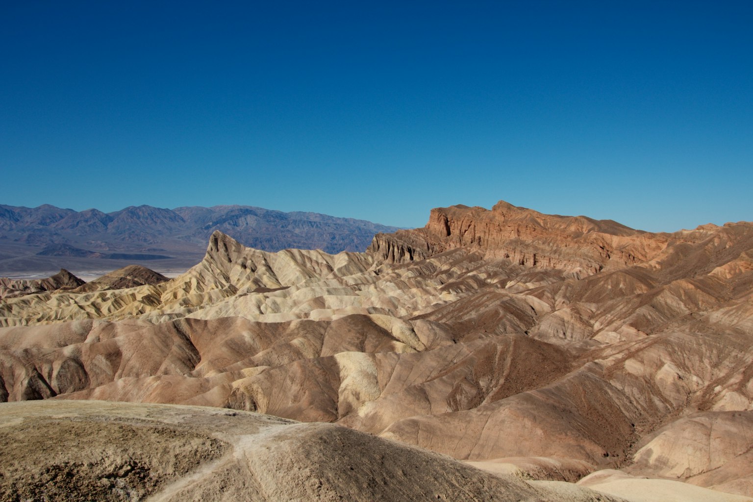 Paesaggio desertico colorato con strati sotto un cielo blu chiaro