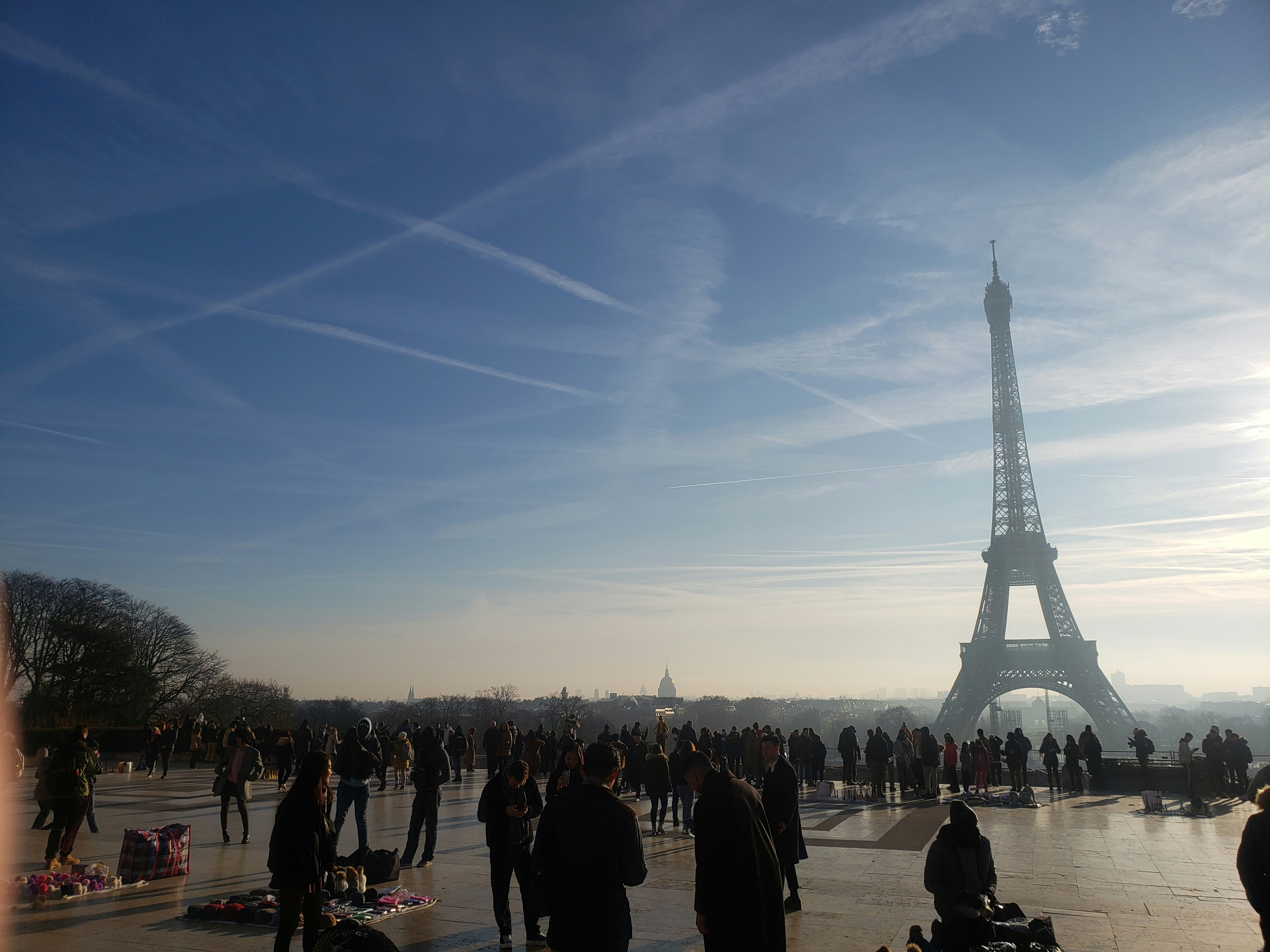 La tour Eiffel flottant dans le ciel au-dessus d’une place animée