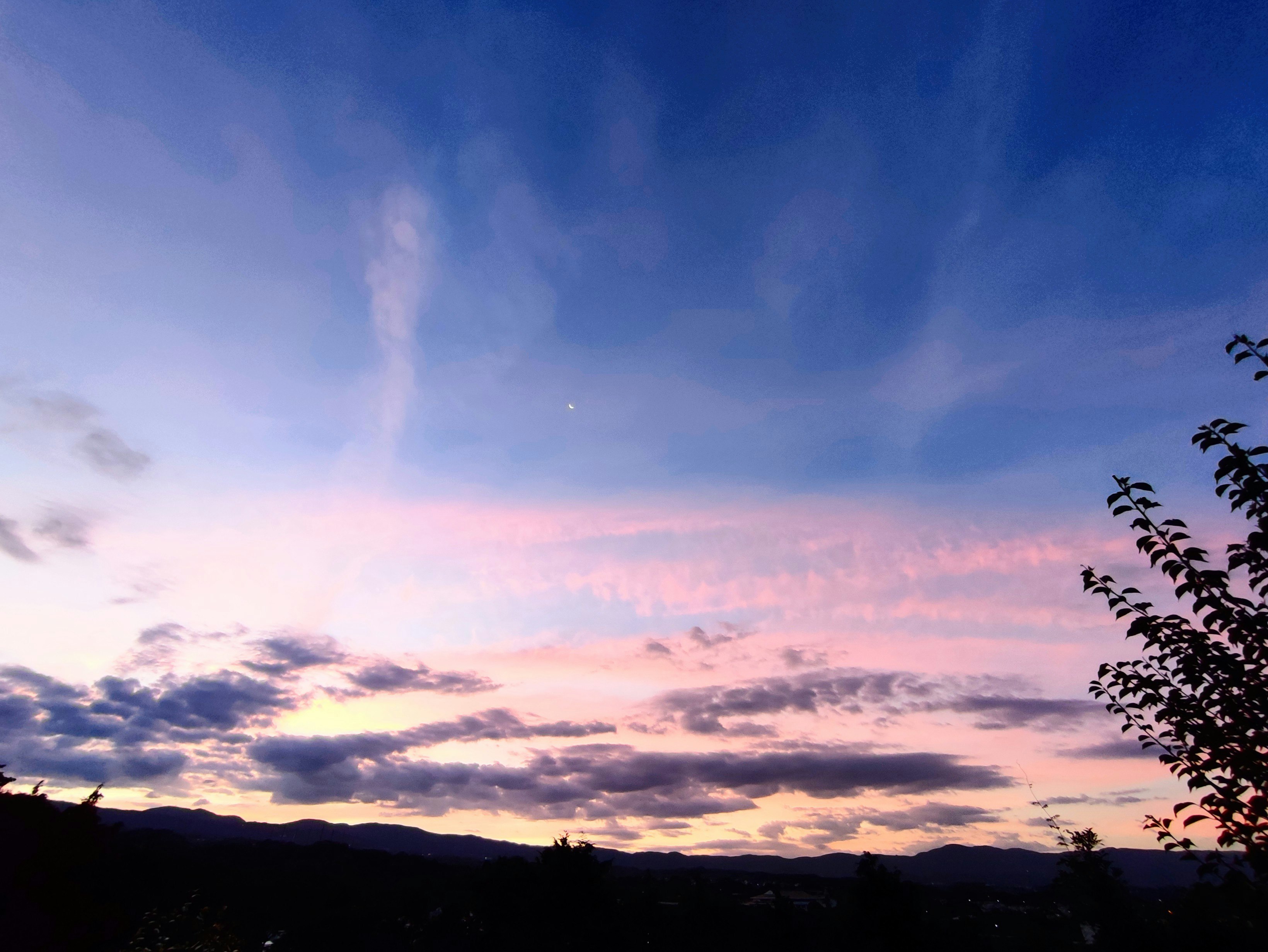 夕焼け空に広がる雲と山並みのシルエット