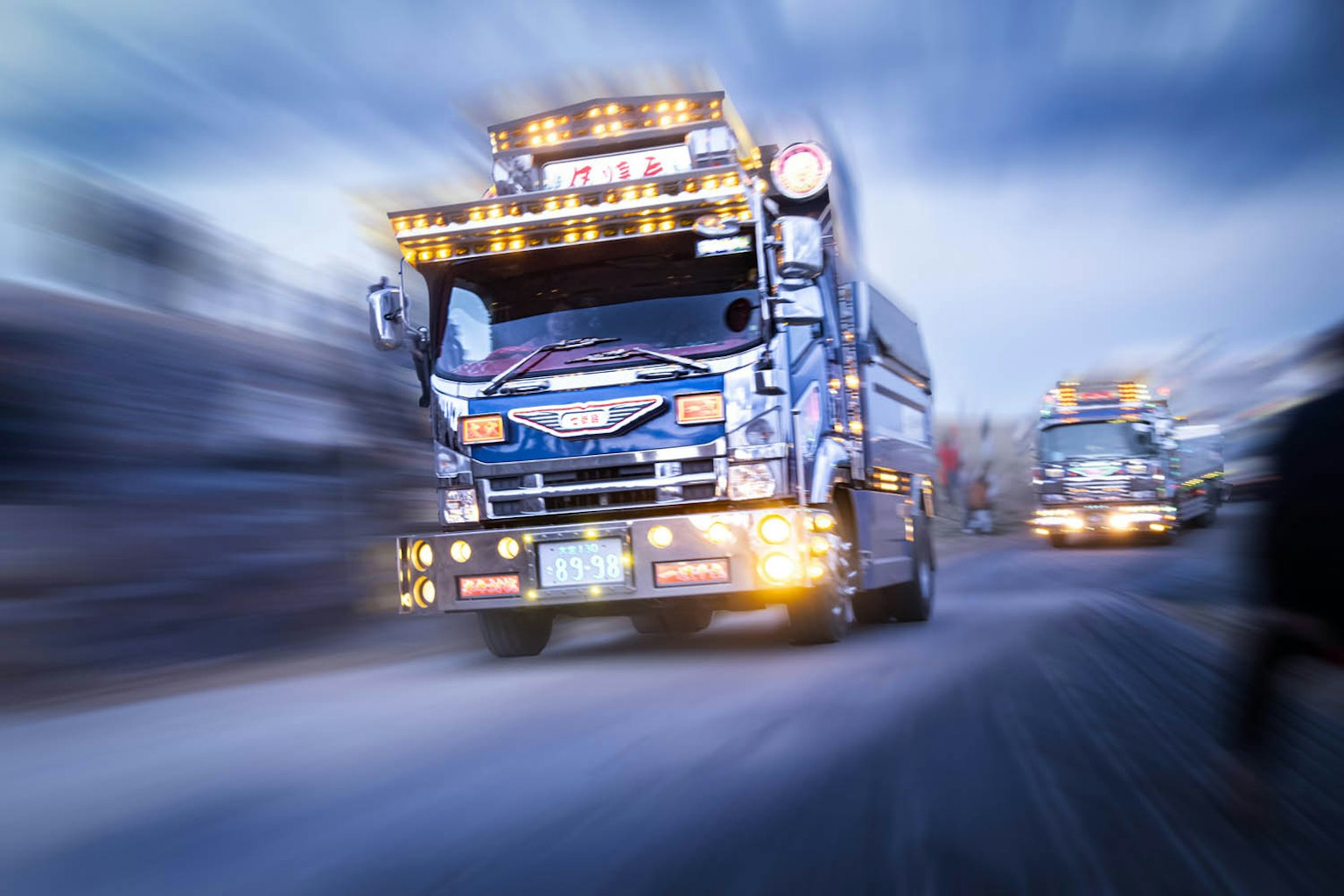 Dynamische Szene eines fahrenden Lastwagens Blauer Lastwagen mit hellen Lichtern geschmückt