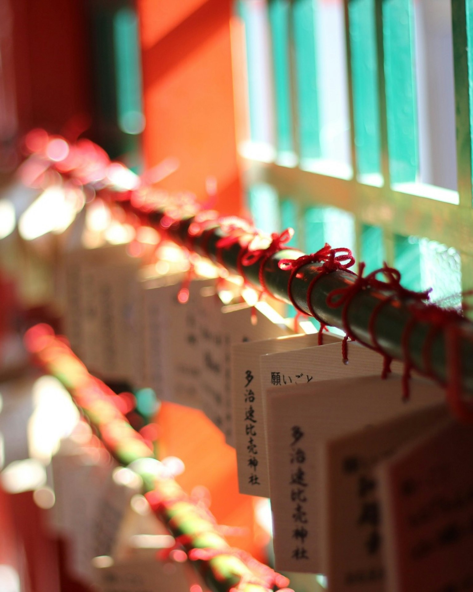 Bright scene of talismans hanging with red ribbons in soft light