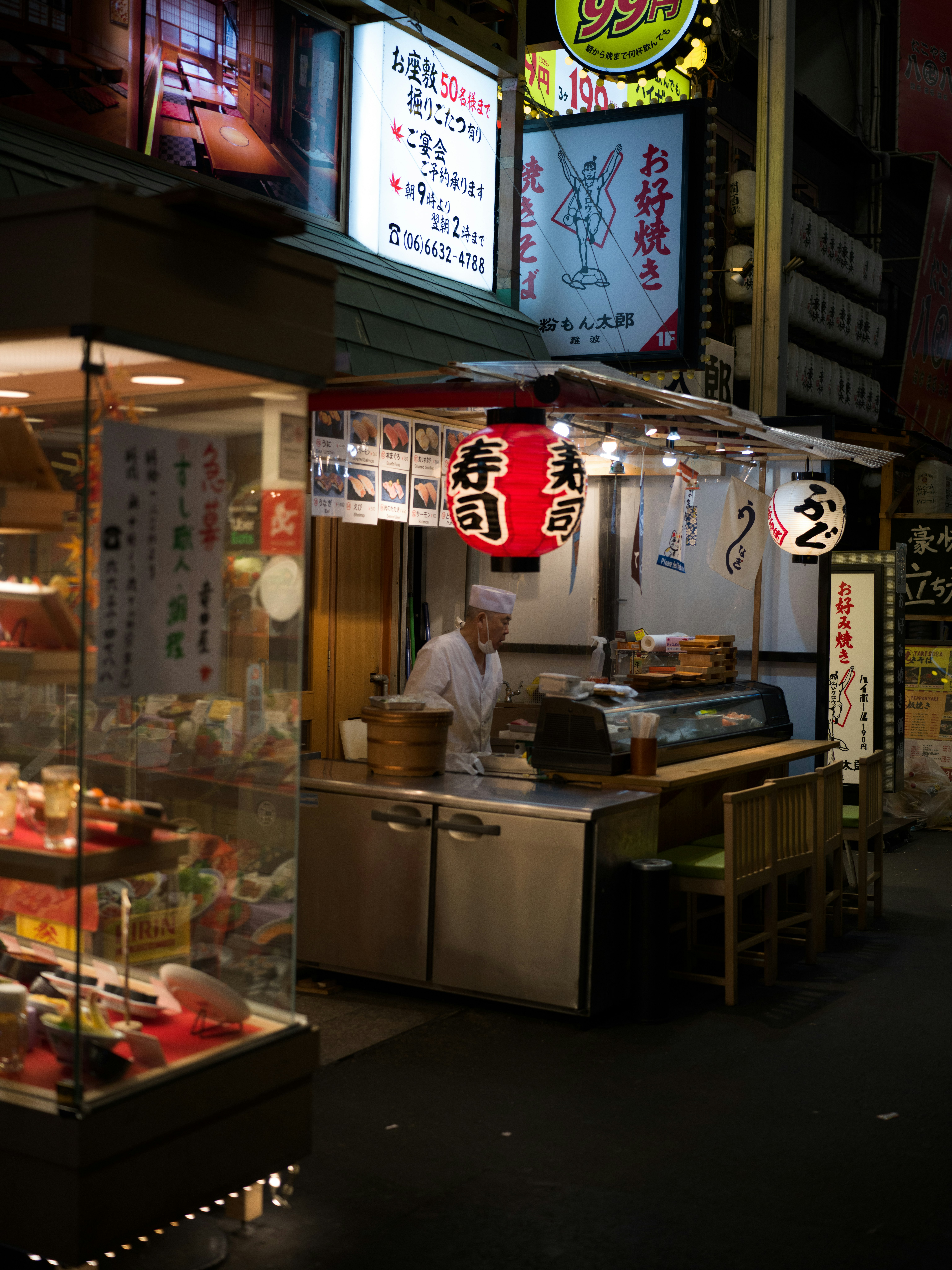 ร้านรถเข็นอาหารในตรอกแคบพร้อมตู้โชว์อาหารและโคมไฟแขวน