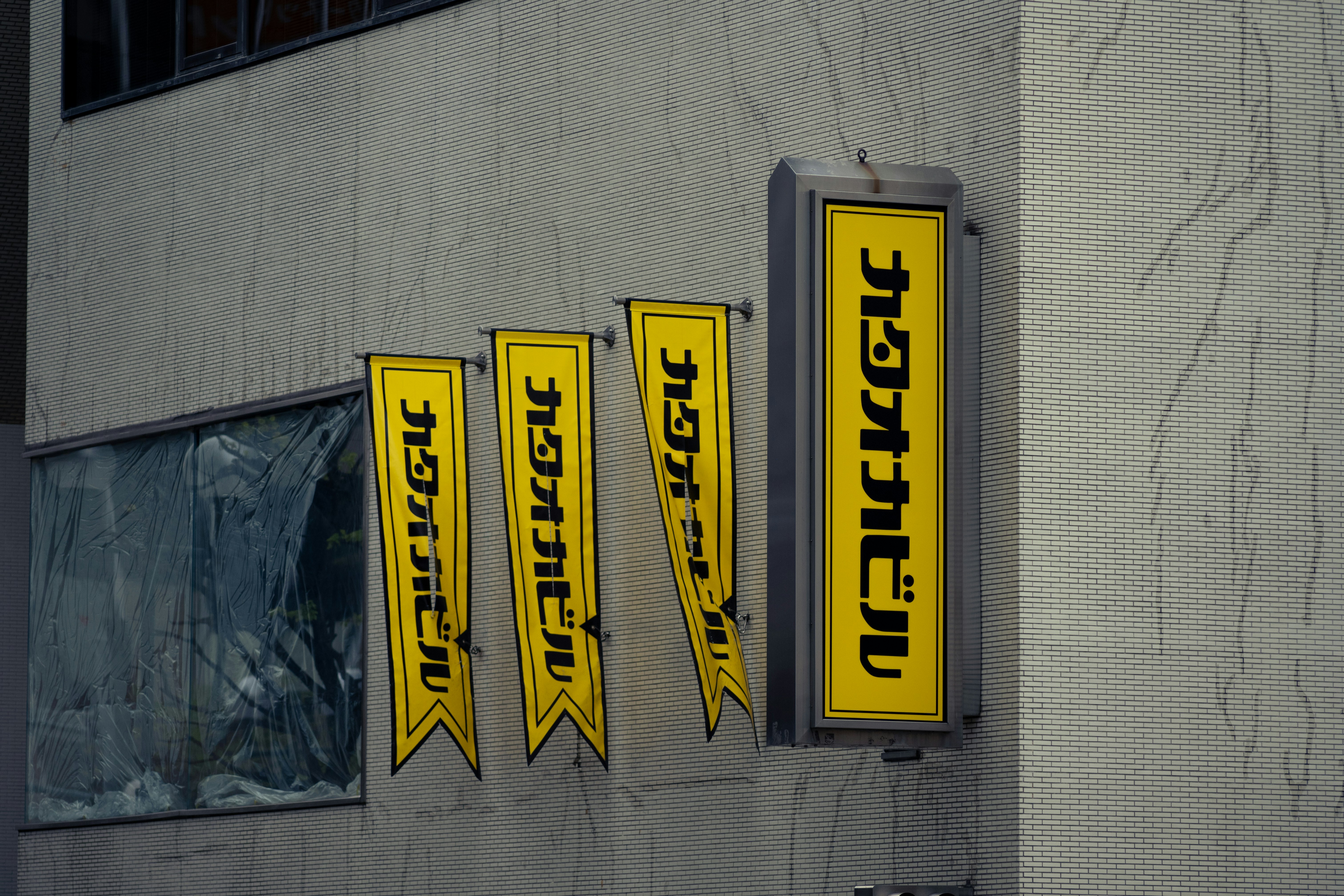Gelbe Ladenbanner und Schilder an einer Gebäudewand