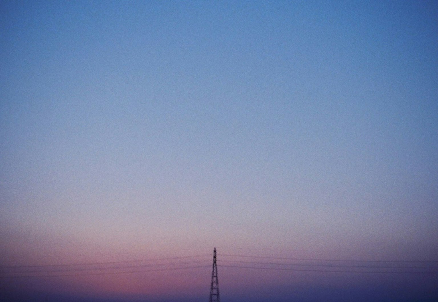 Ciel dégradé avec des teintes bleues et roses douces présentant une tour de transmission