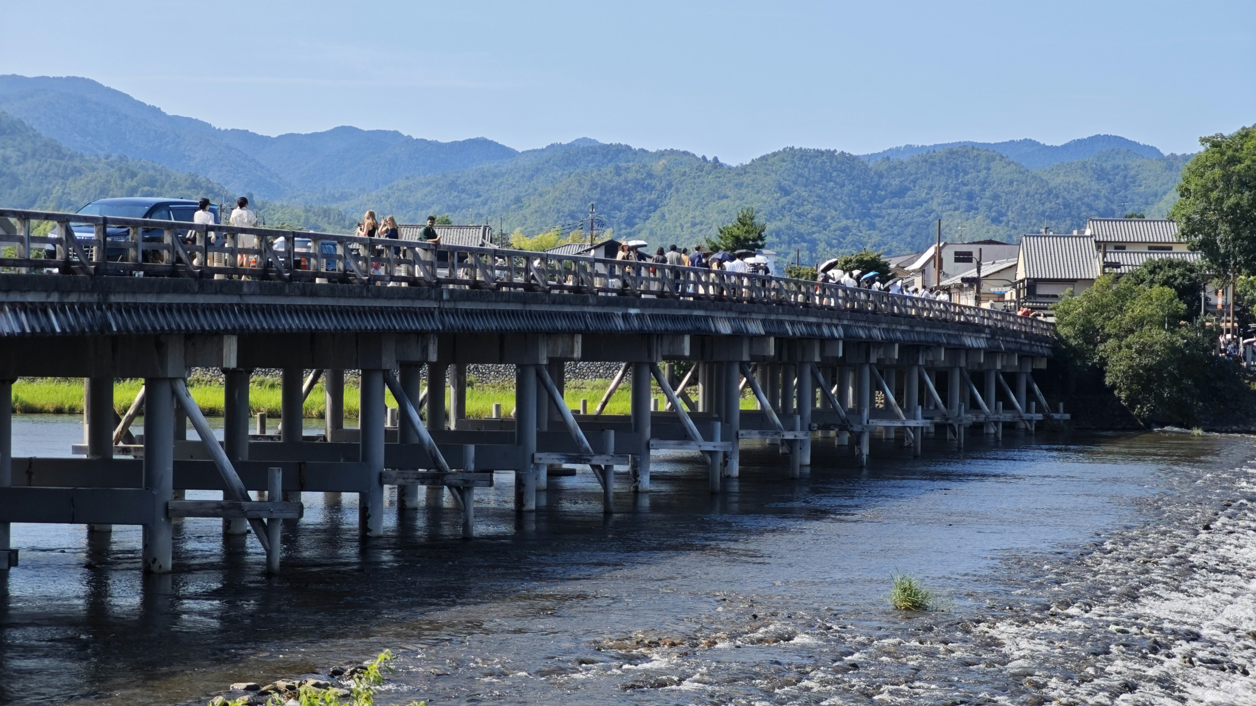 Summer Togetsukyo Bridge over a river with Arashiyama mountain views