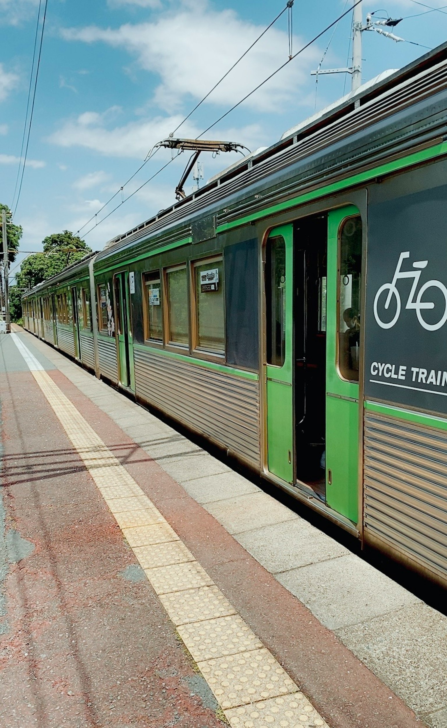 Train avec symbole de bicyclette verte arrêté à une gare