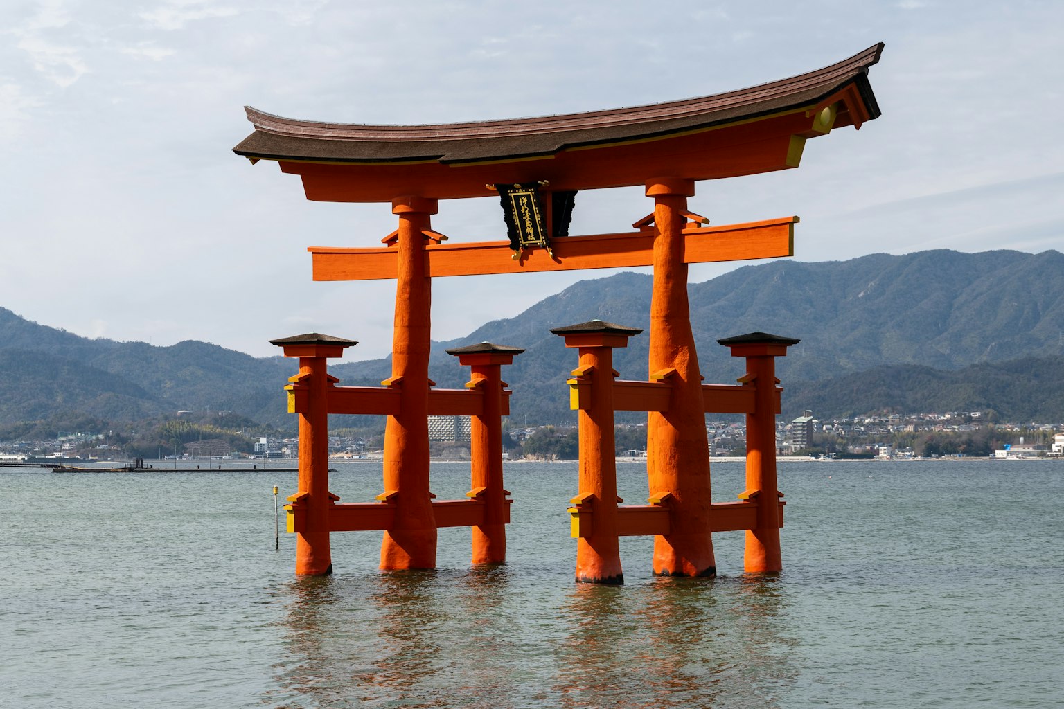 Ein schöner Torii in Wasser stehend mit Bergen im Hintergrund