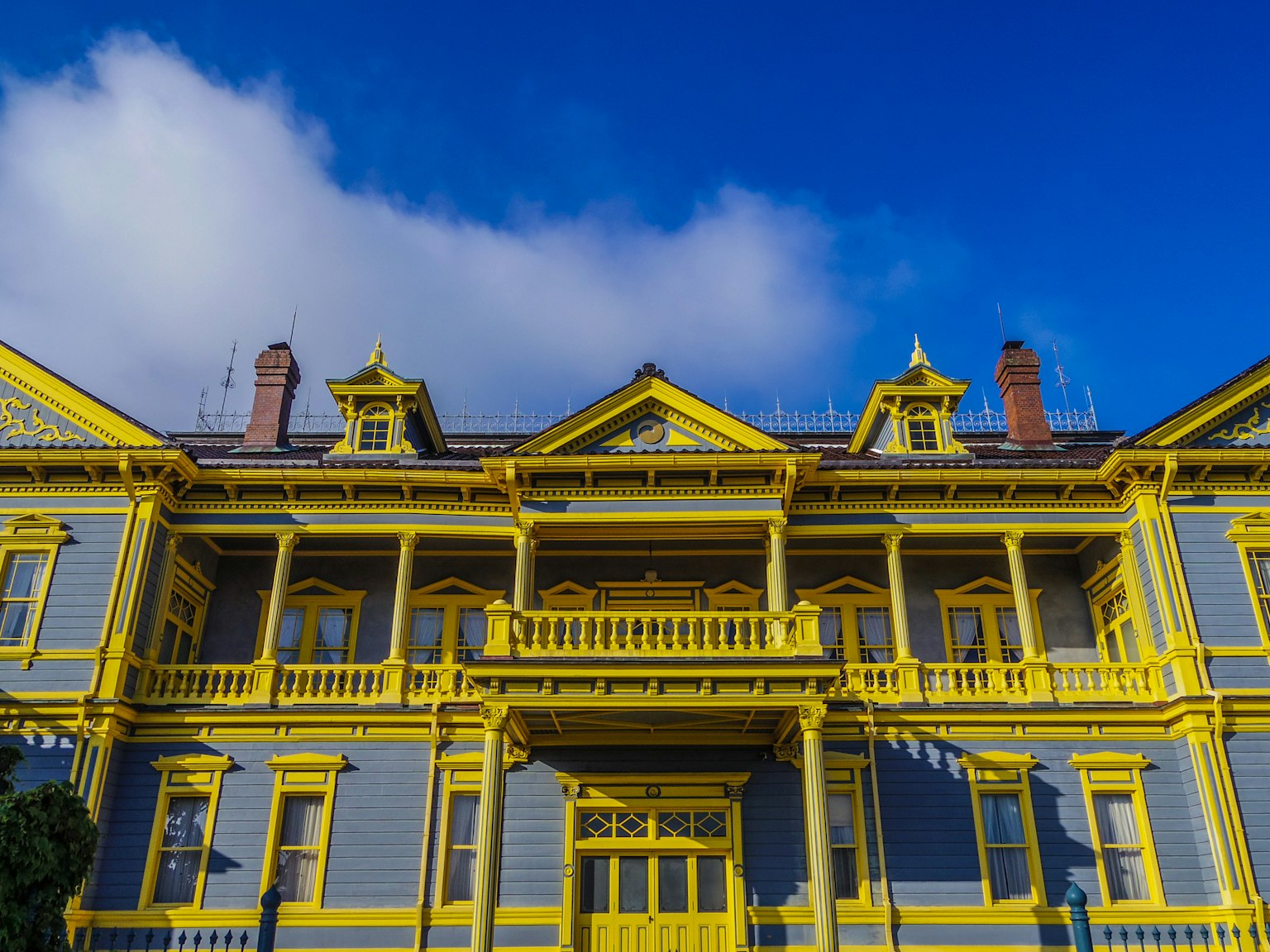 Edificio histórico con exterior amarillo brillante bajo un cielo azul