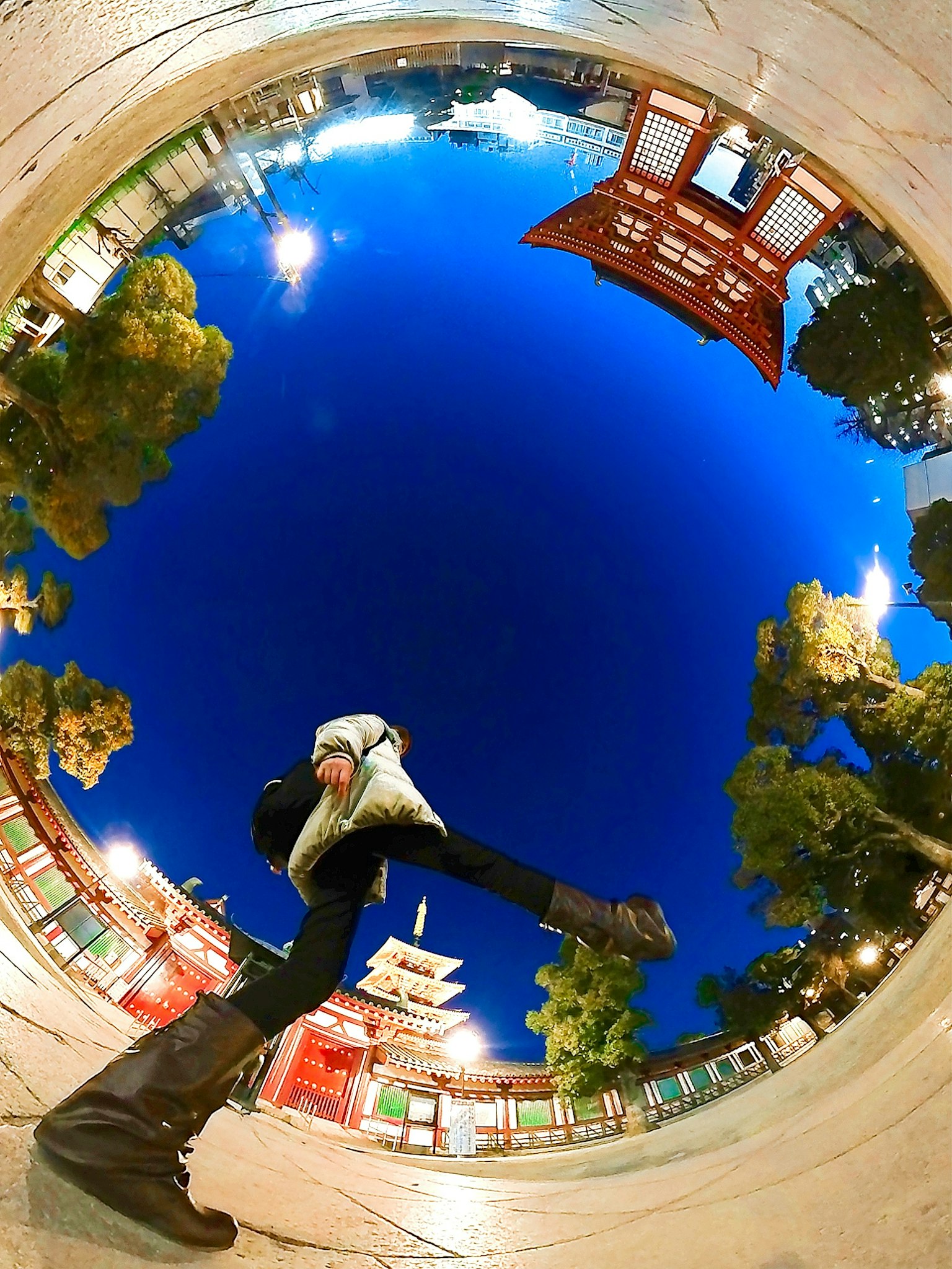 A person dancing under the night sky captured in a unique fisheye lens perspective