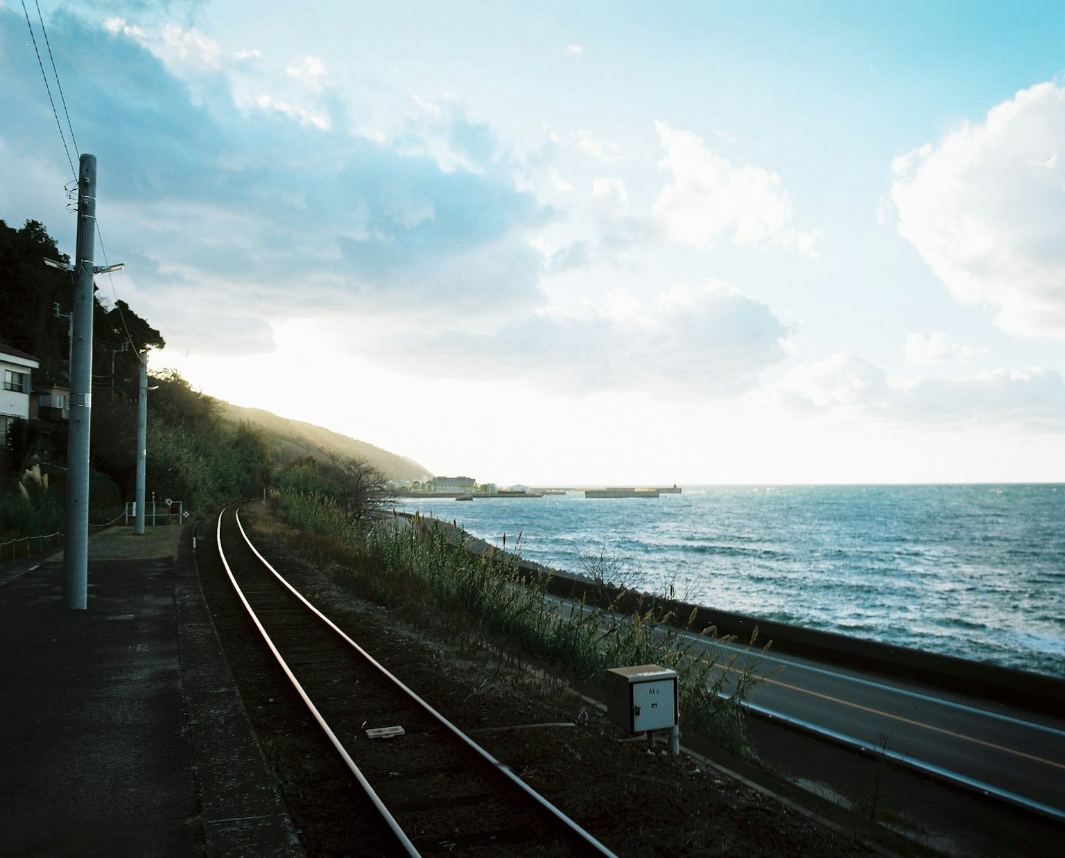 Vista panoramica dei binari ferroviari lungo la costa con cielo blu