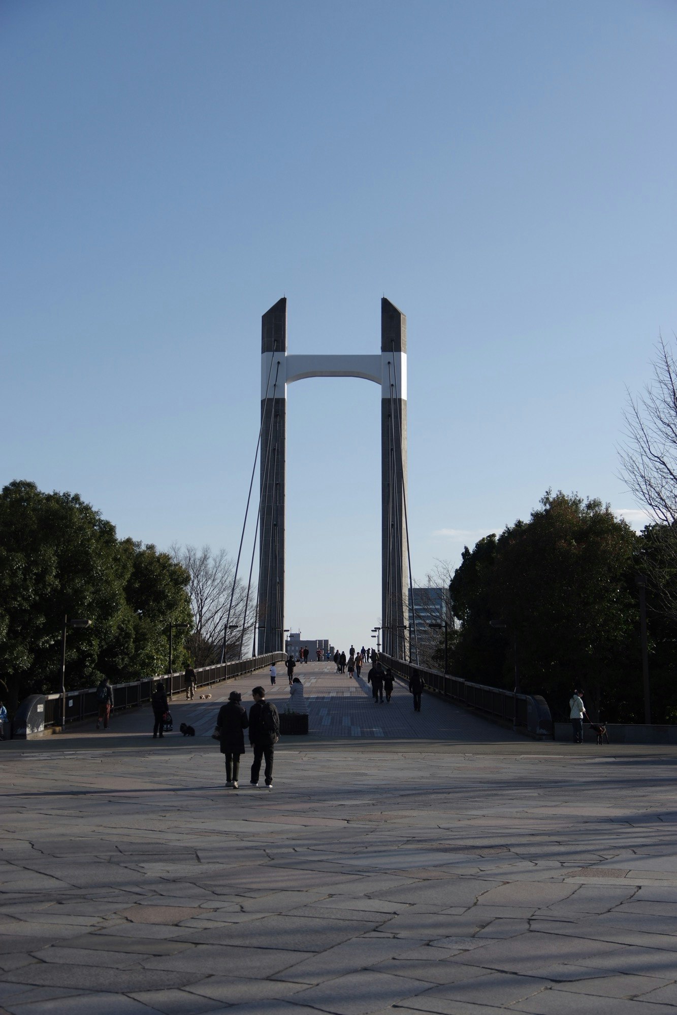 persone che camminano in una piazza con un monumento alto
