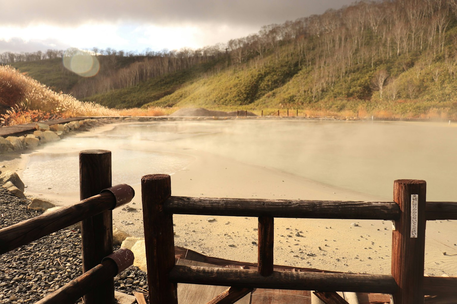 Pagar kayu di dekat danau dengan pemandangan pegunungan