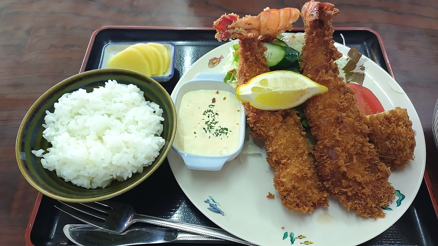 Teller mit frittierten Garnelen, Reis und Sauce, serviert mit Zitrone